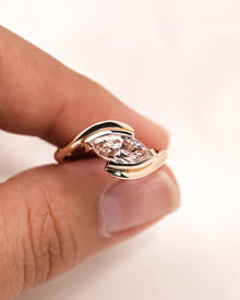 Angled view of pink marquise lab grown diamond twist ring with twisted band setting