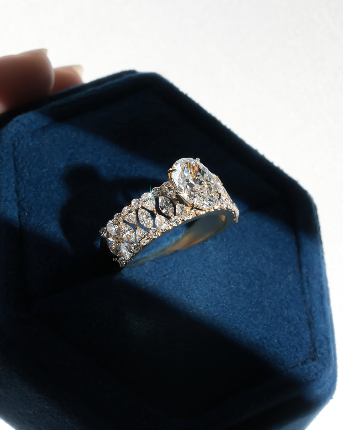 Oval cluster lab grown diamond ring angled in a blue Ronora box