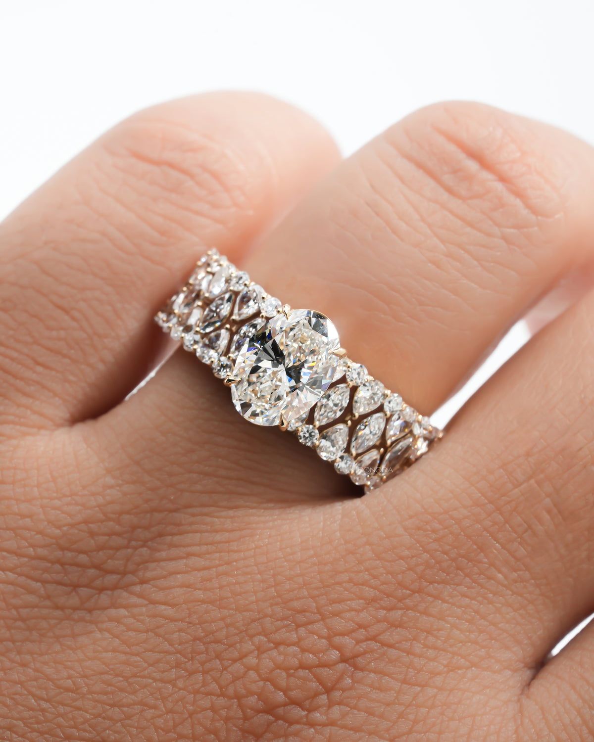 Oval cluster lab grown diamond ring worn on the hand from above