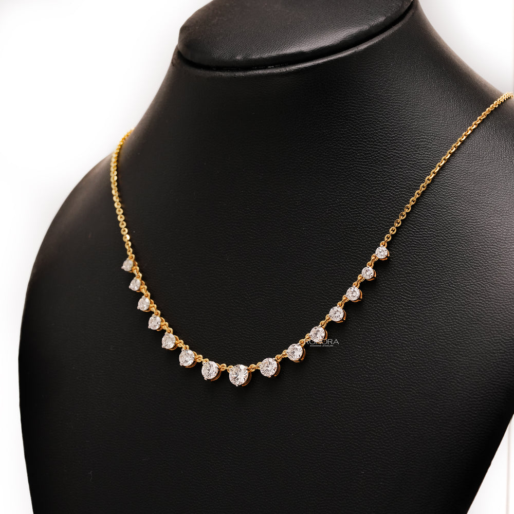 Yellow gold round lab grown diamond tennis necklace shown at an angle on a black display bust