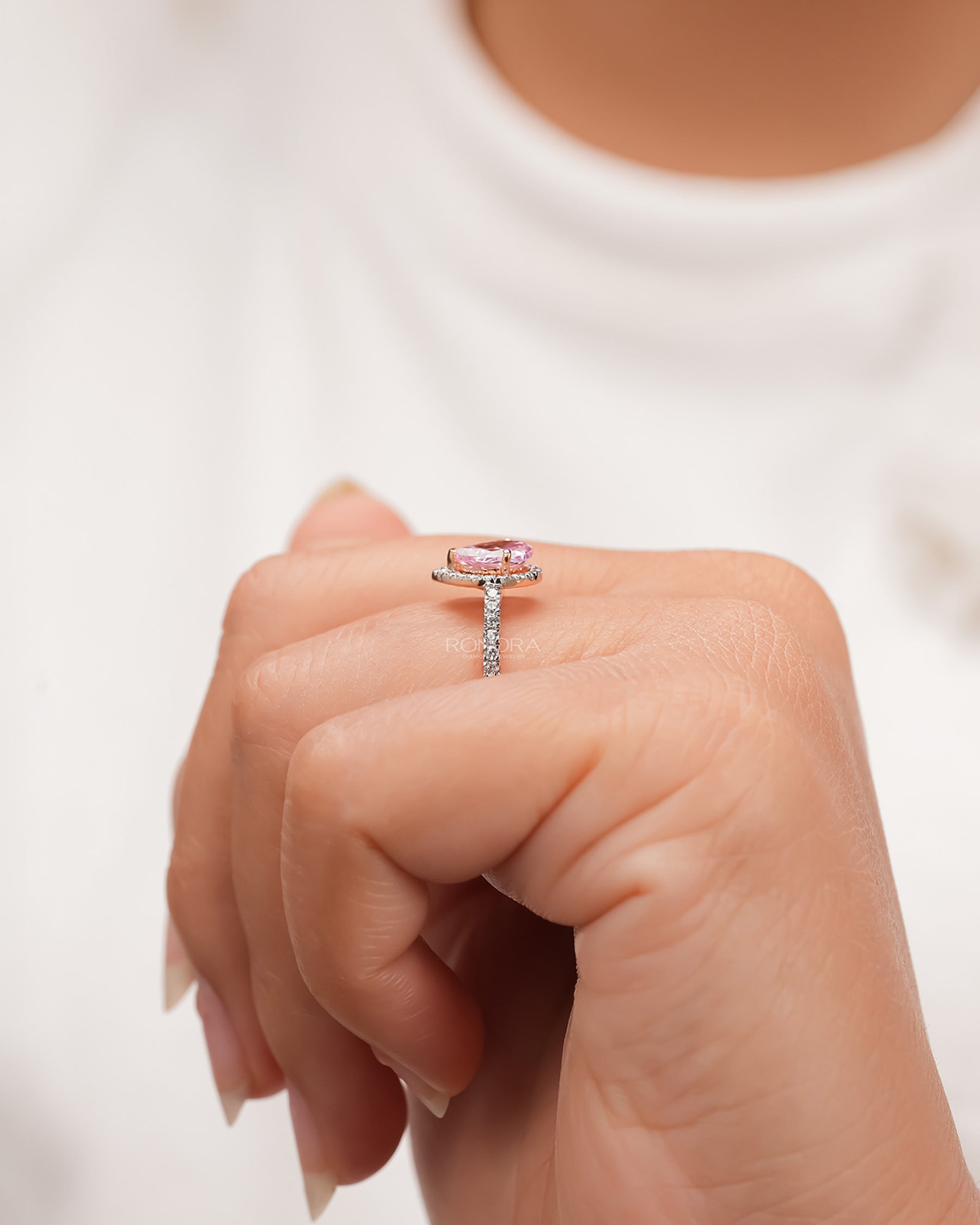 pink pear moissanite halo ring worn with luxury styling in rose gold
