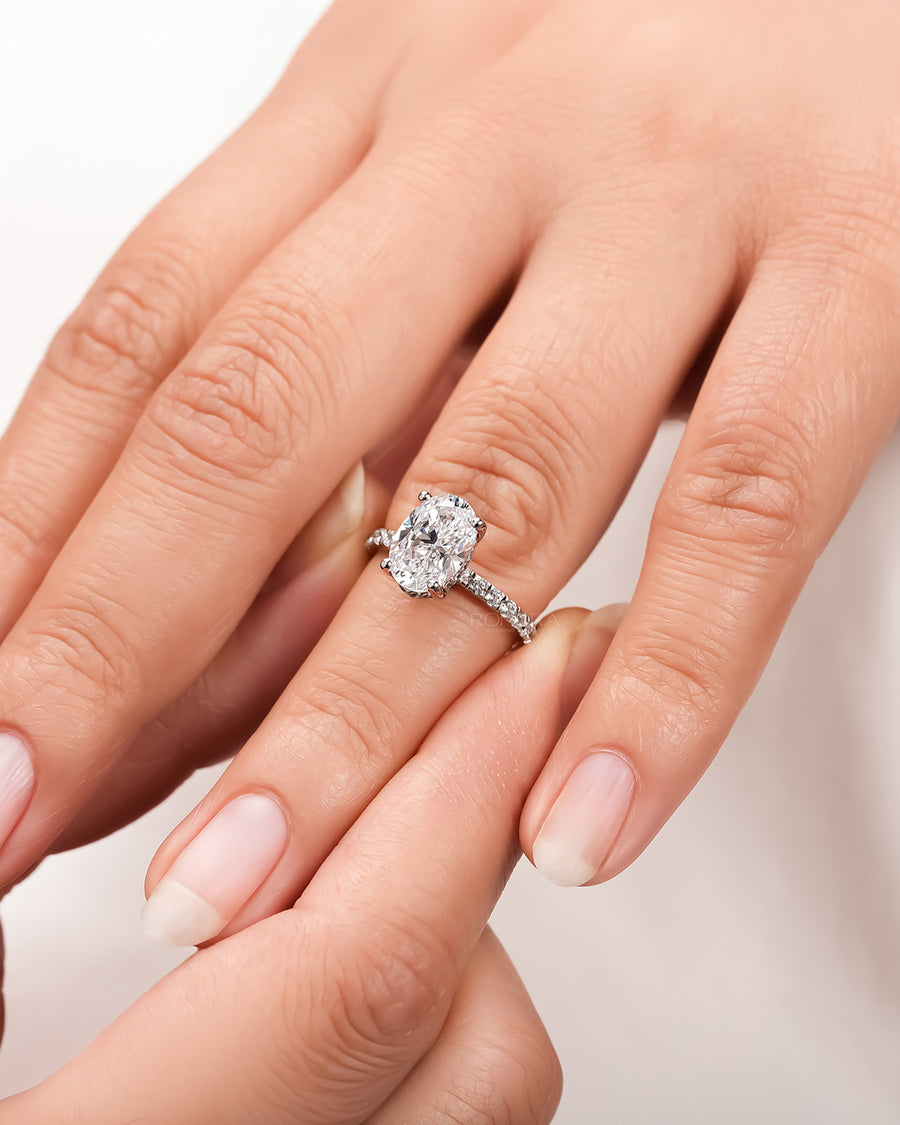 oval moissanite pave ring worn on hand in rose gold