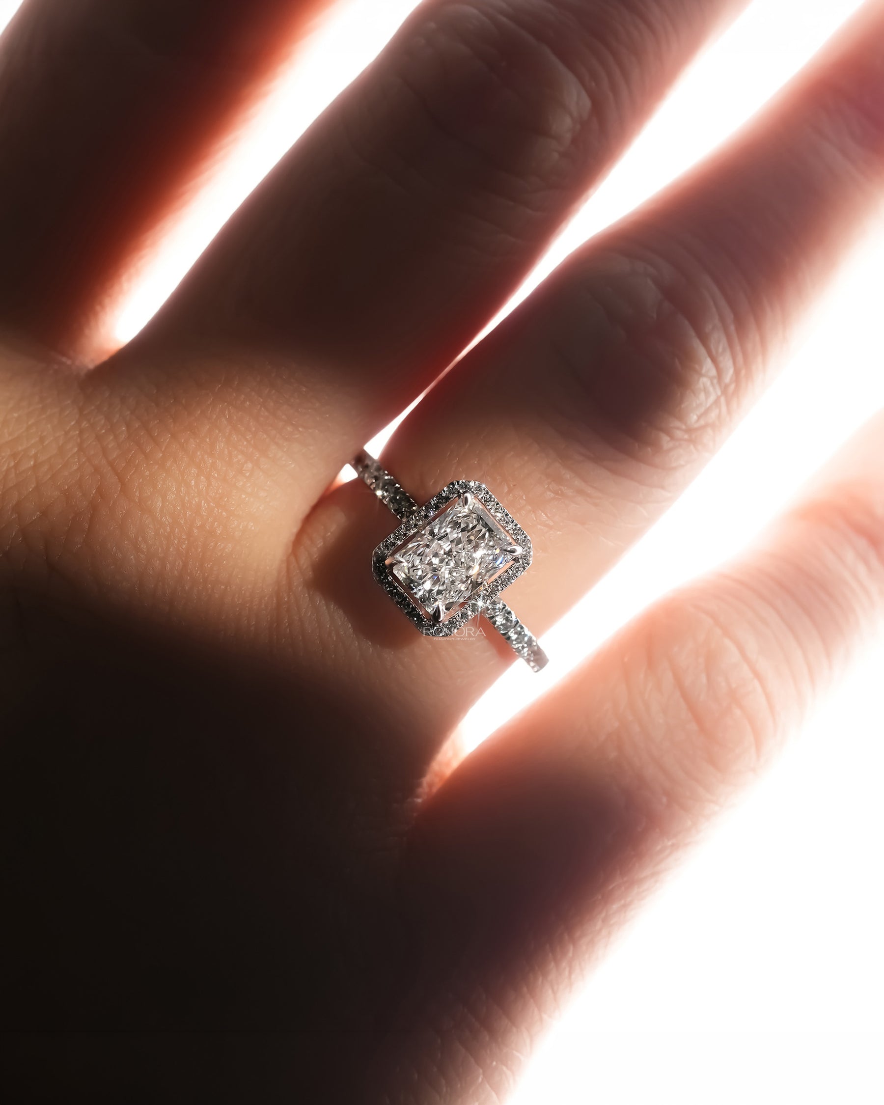 radiant lab grown diamond halo ring worn on hand in white gold