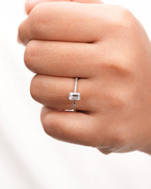 emerald cut moissanite pave ring worn on hand in rose gold