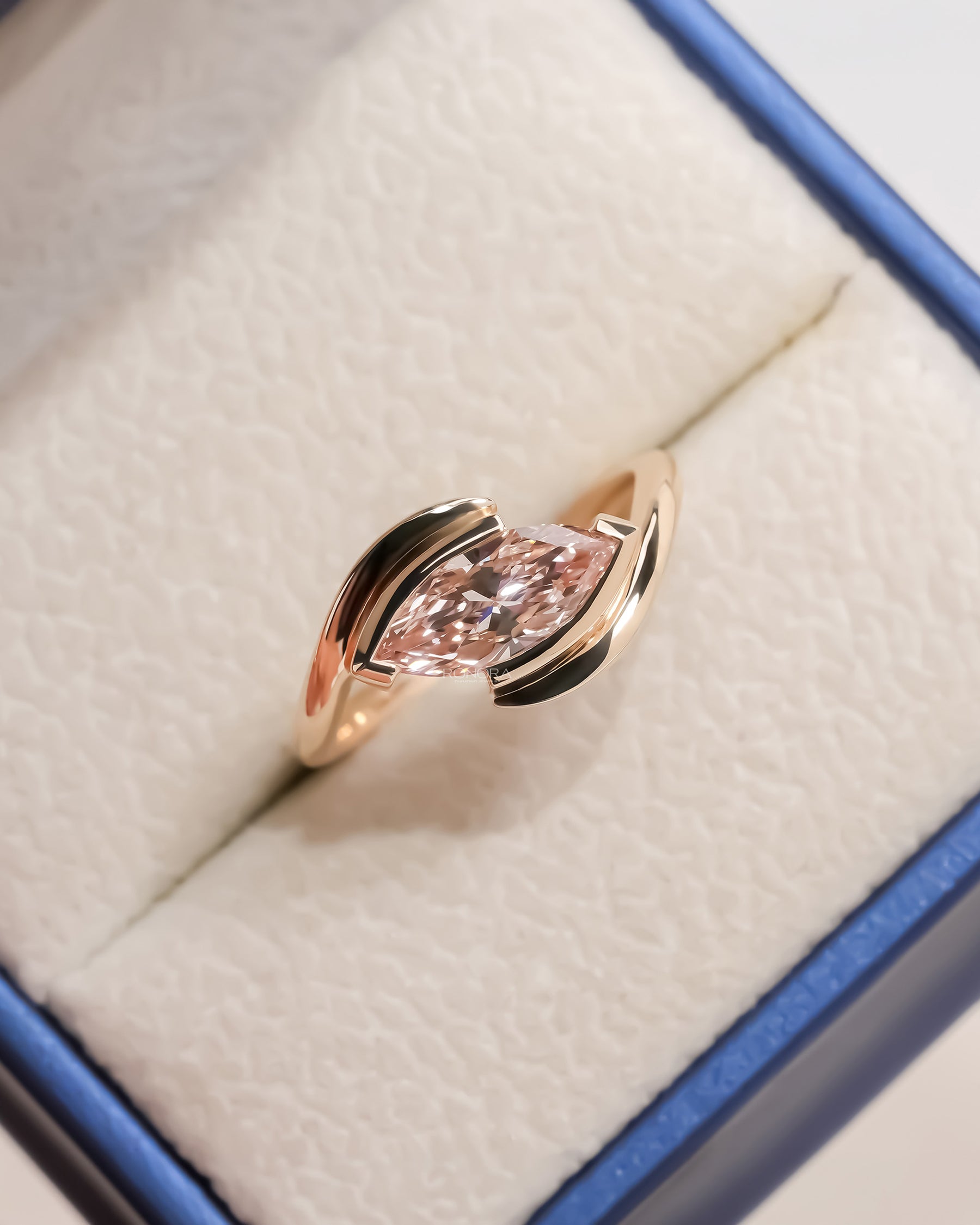 pink marquise lab grown diamond twist ring worn on hand in rose gold