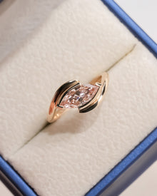 pink marquise lab grown diamond twist ring worn on hand in rose gold