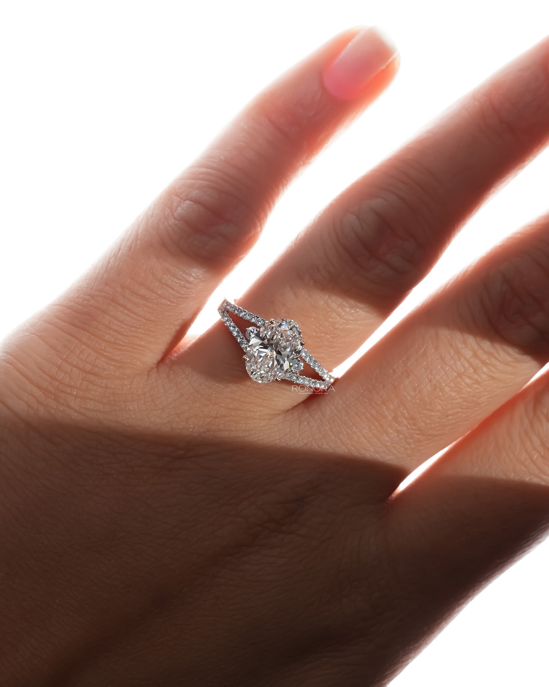 oval lab grown diamond halo ring worn with luxury styling in white gold