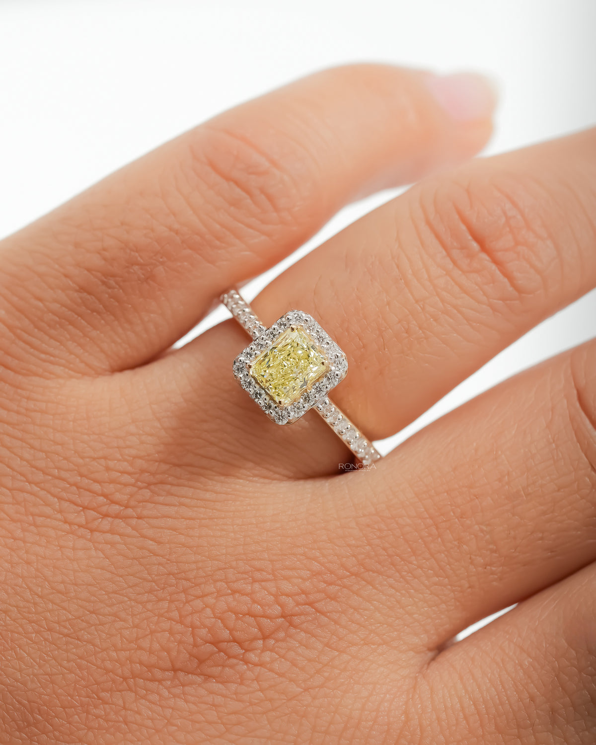 Fancy yellow lab grown diamond halo ring worn on the hand
