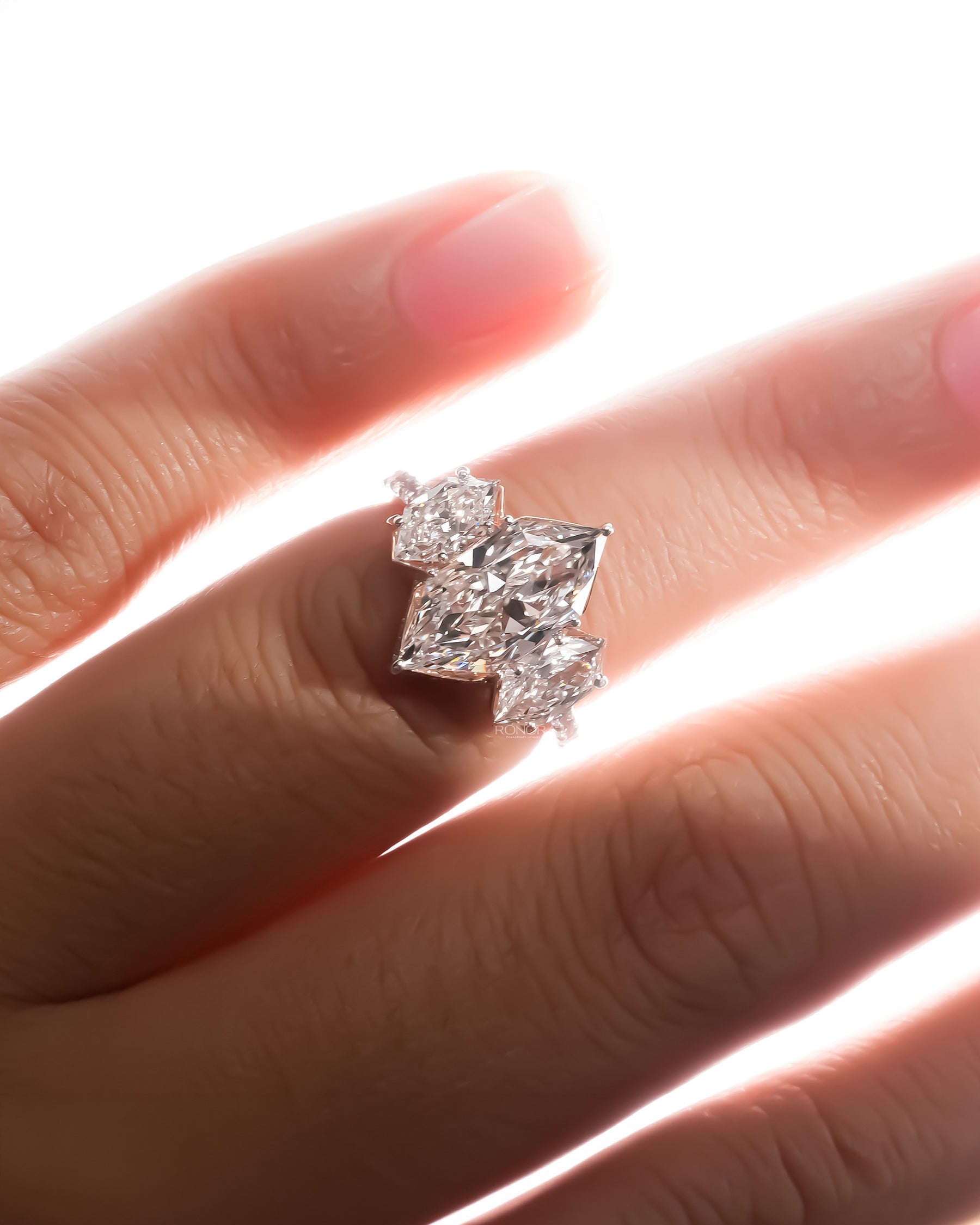 marquise lab grown diamond three-stone ring worn with luxury styling in white gold