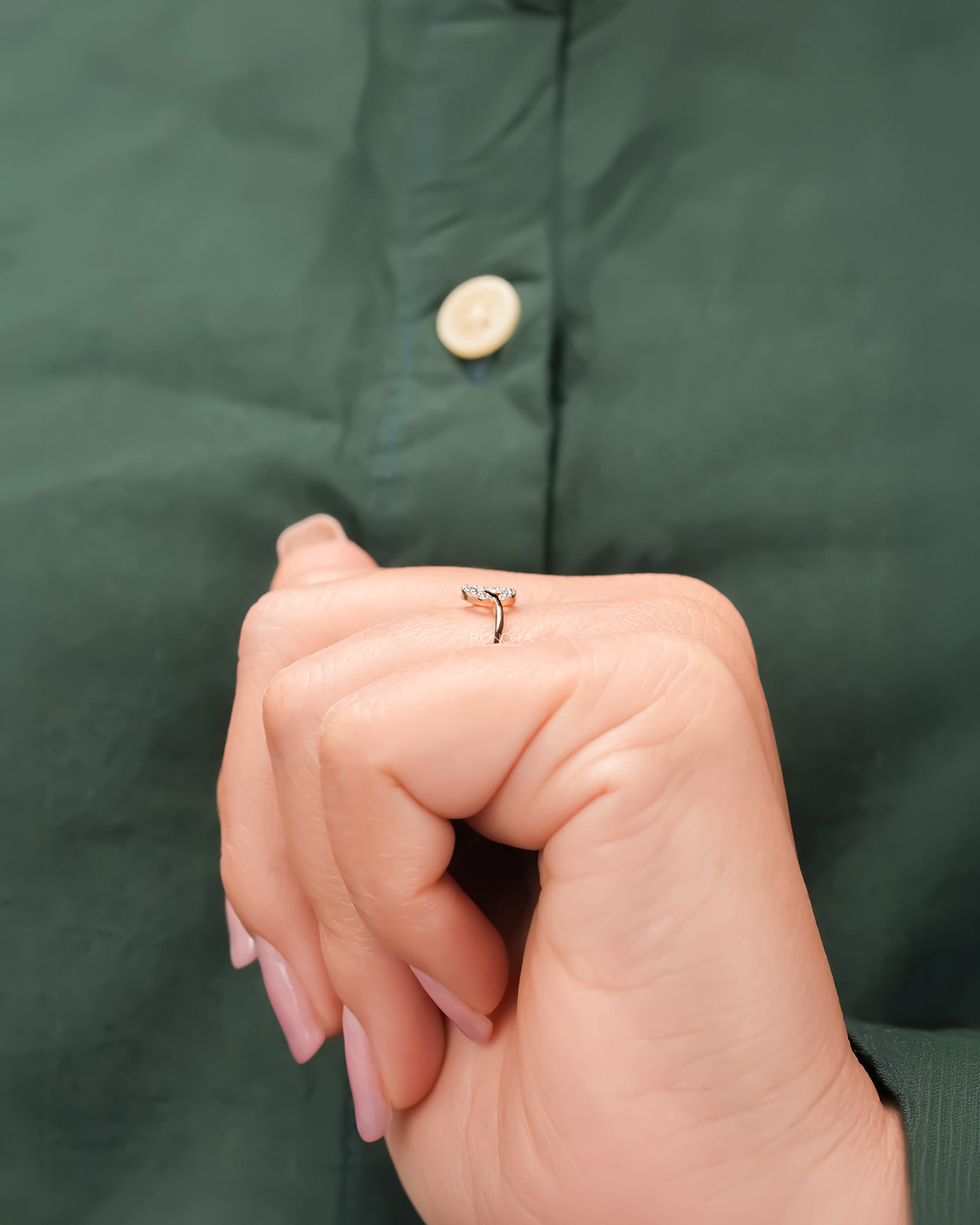 Round lab grown diamond bypass ring worn with dark green styling