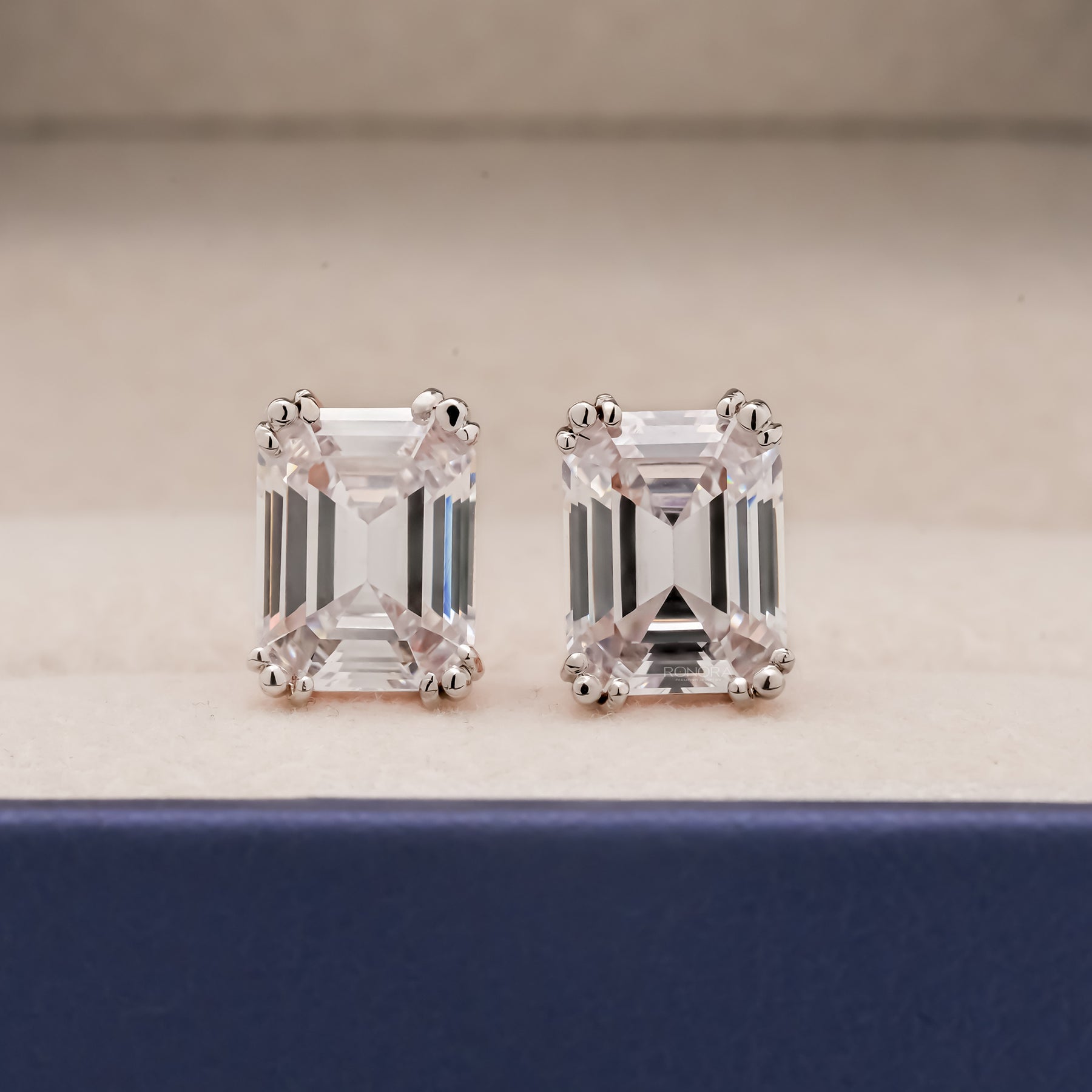 Front view of emerald lab grown diamond stud earrings with prong setting