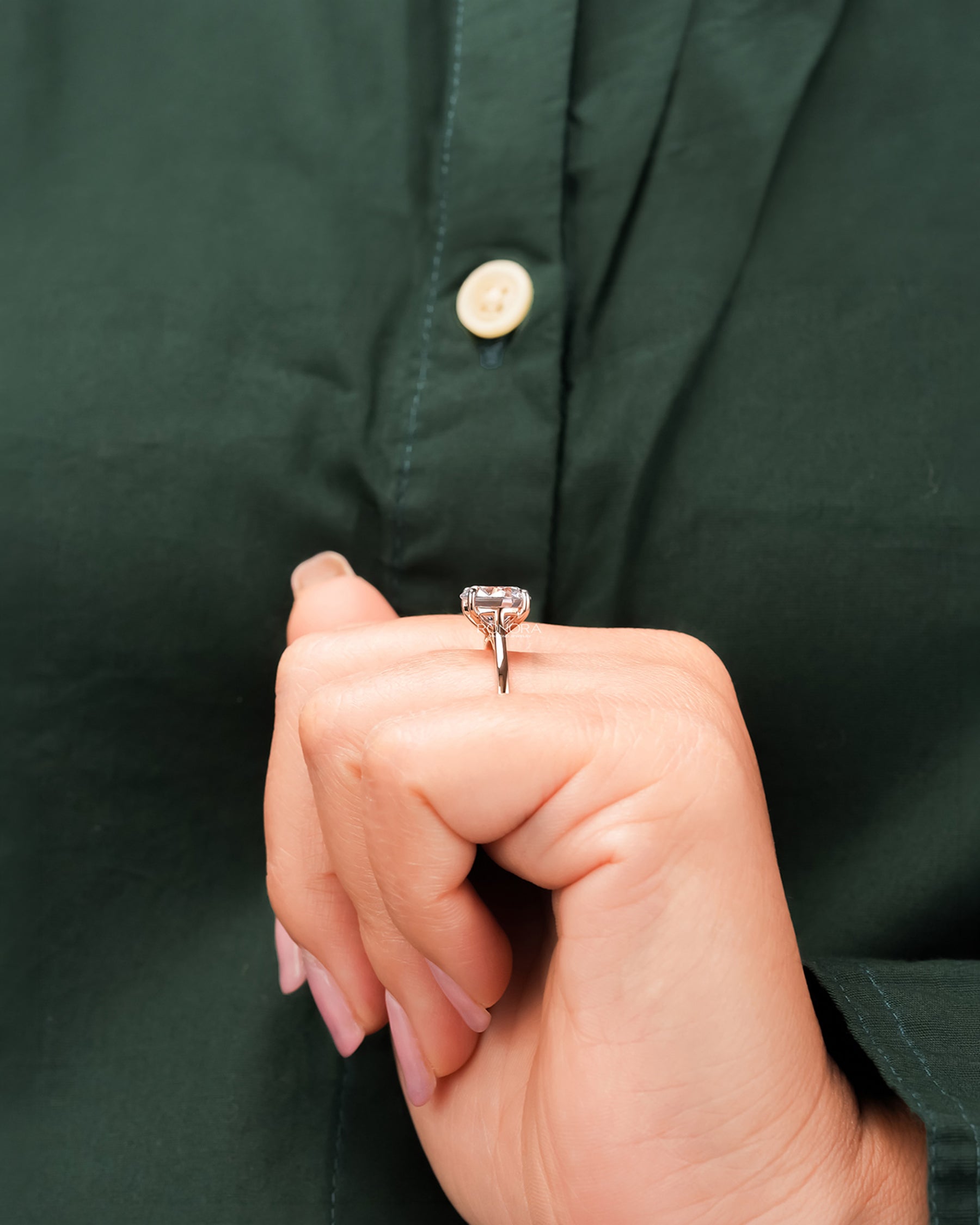 Round moissanite solitaire ring worn with dark green styling