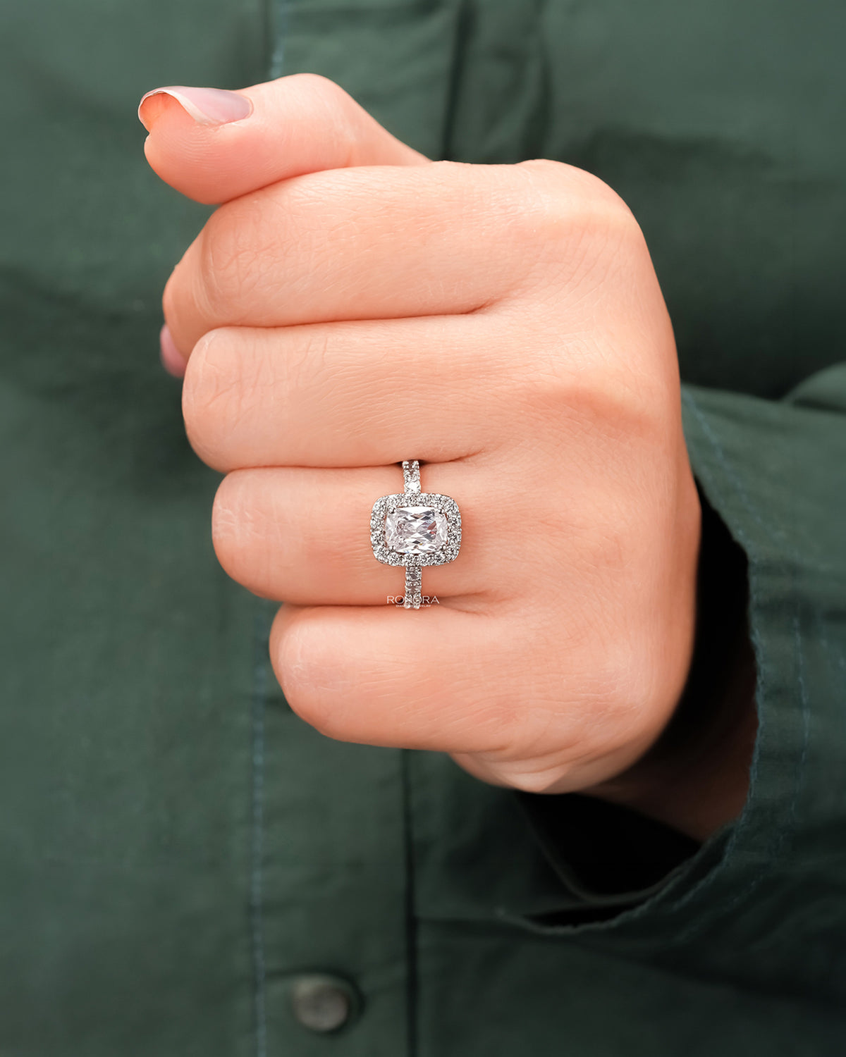 Cushion moissanite halo ring worn on hand in rose gold