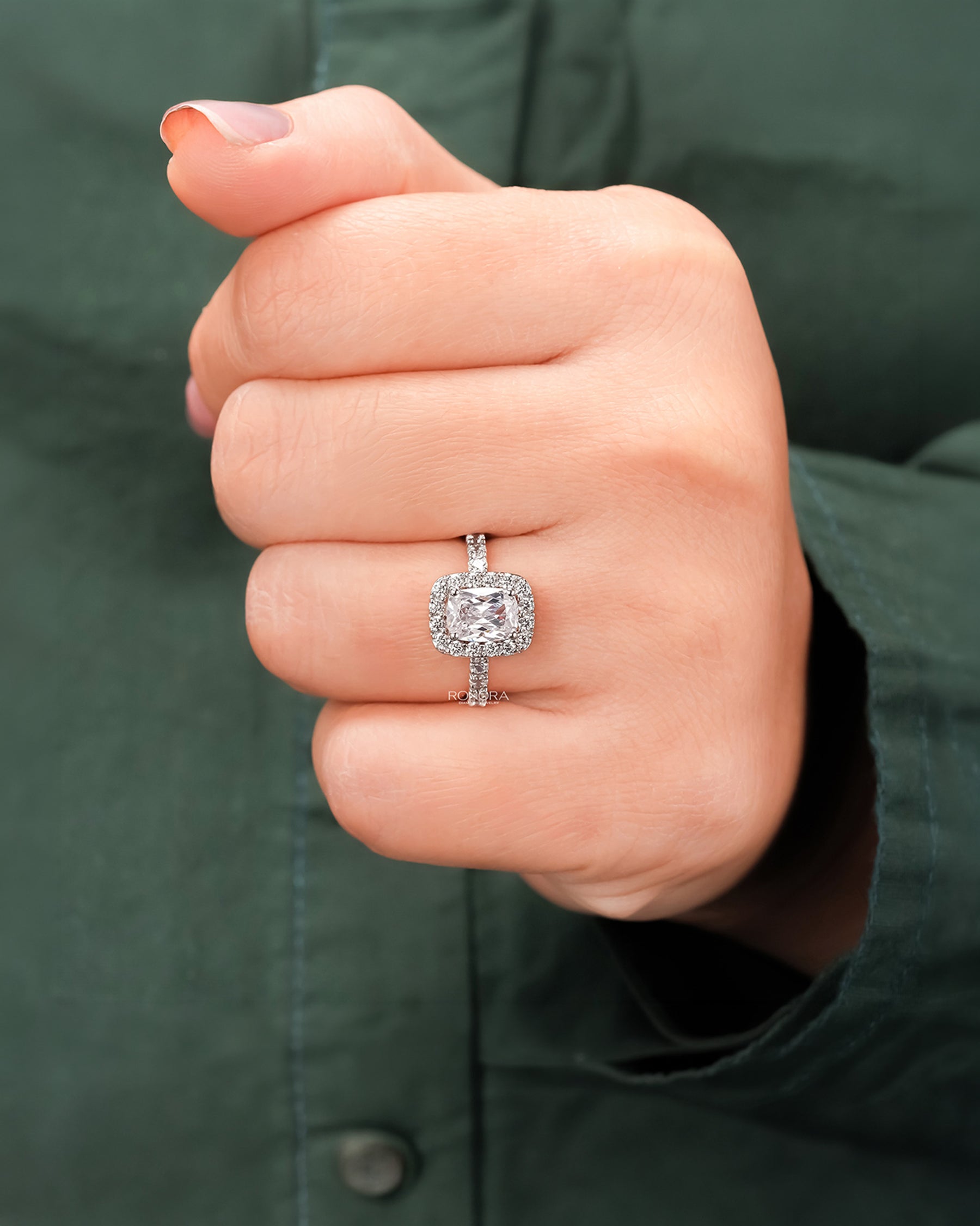 Cushion moissanite halo ring worn on hand in rose gold