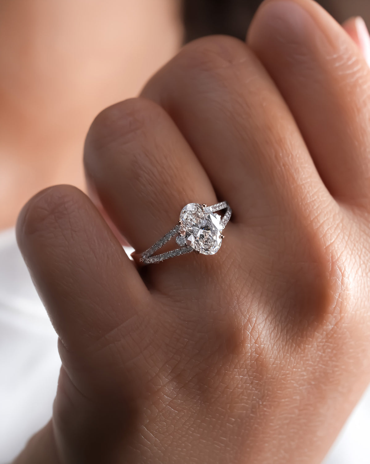 oval lab grown diamond halo ring worn on hand in white gold