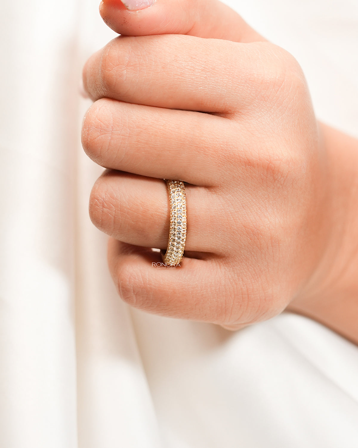 Wide lab grown diamond pavé band worn on hand in yellow gold