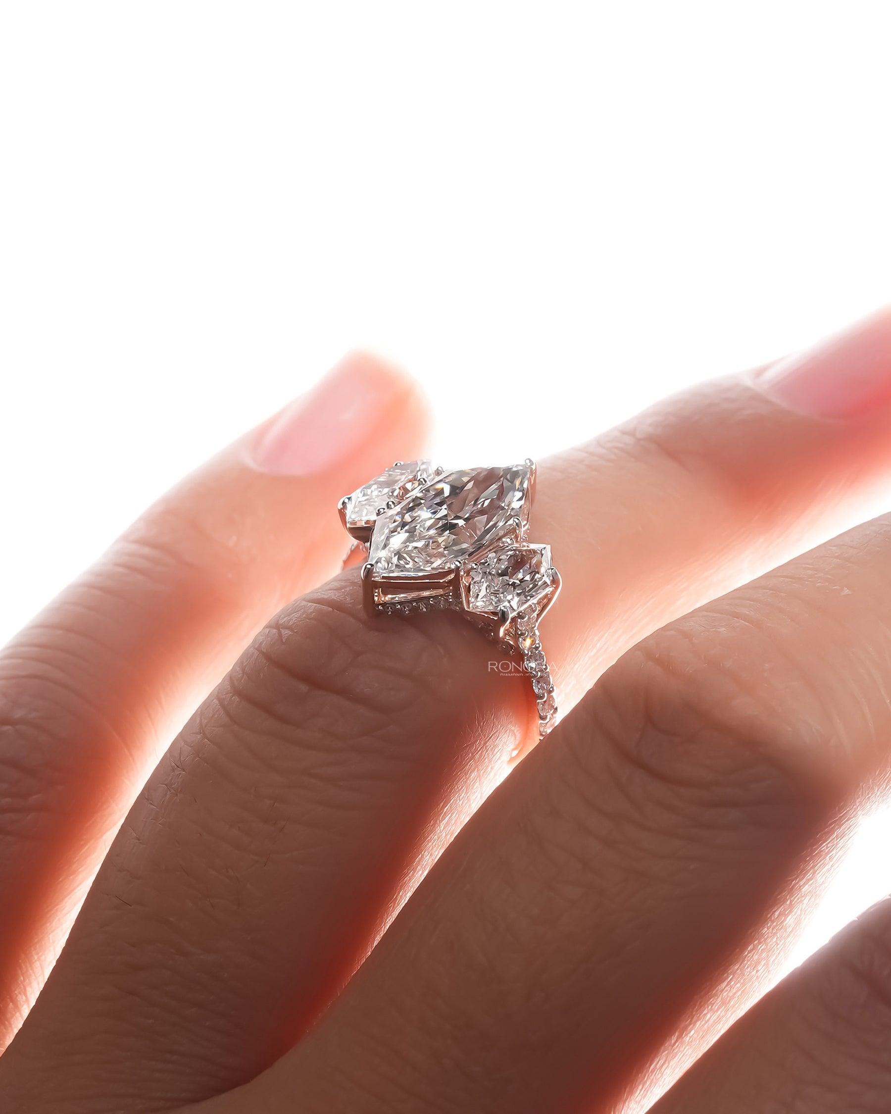 marquise lab grown diamond three-stone ring on hand with refined white gold finish