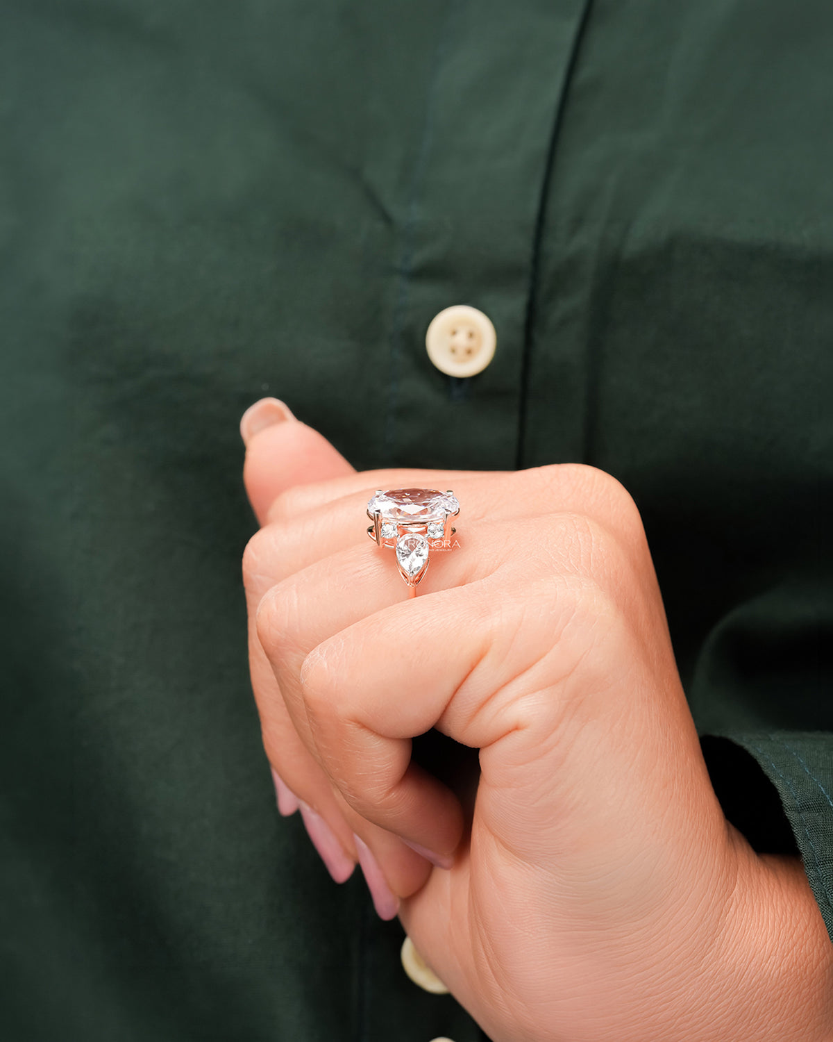 Oval moissanite three-stone ring worn with dark green styling