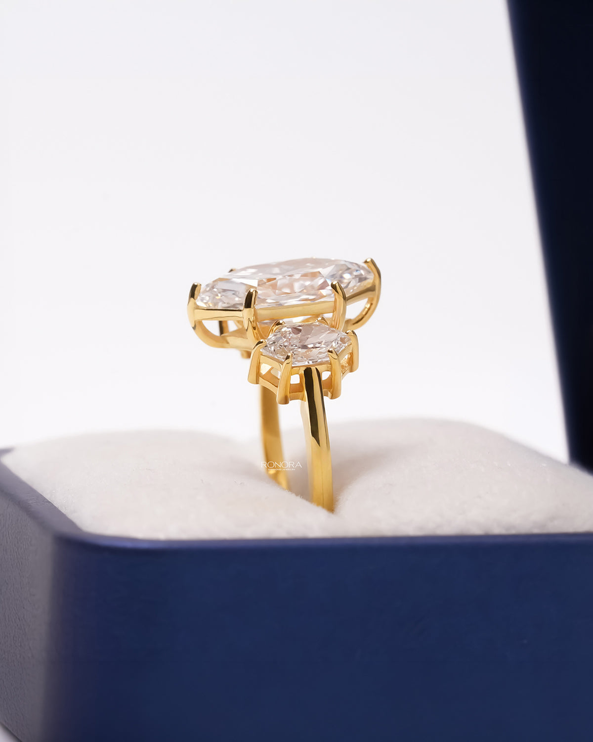 Side profile of yellow gold marquise three-stone ring showing raised gallery