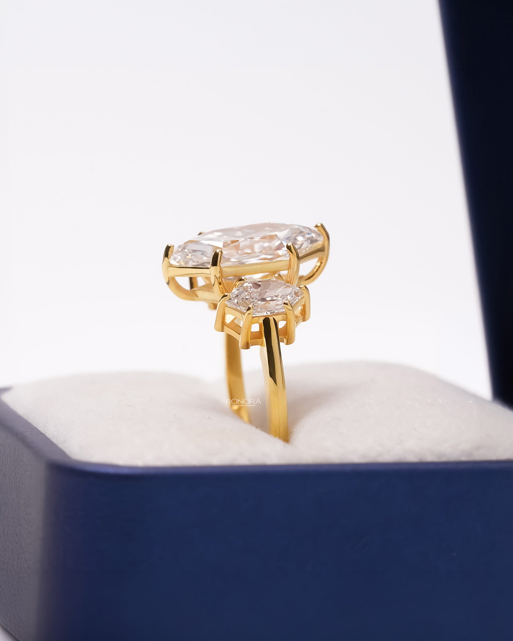 Side profile of yellow gold marquise three-stone ring showing raised gallery
