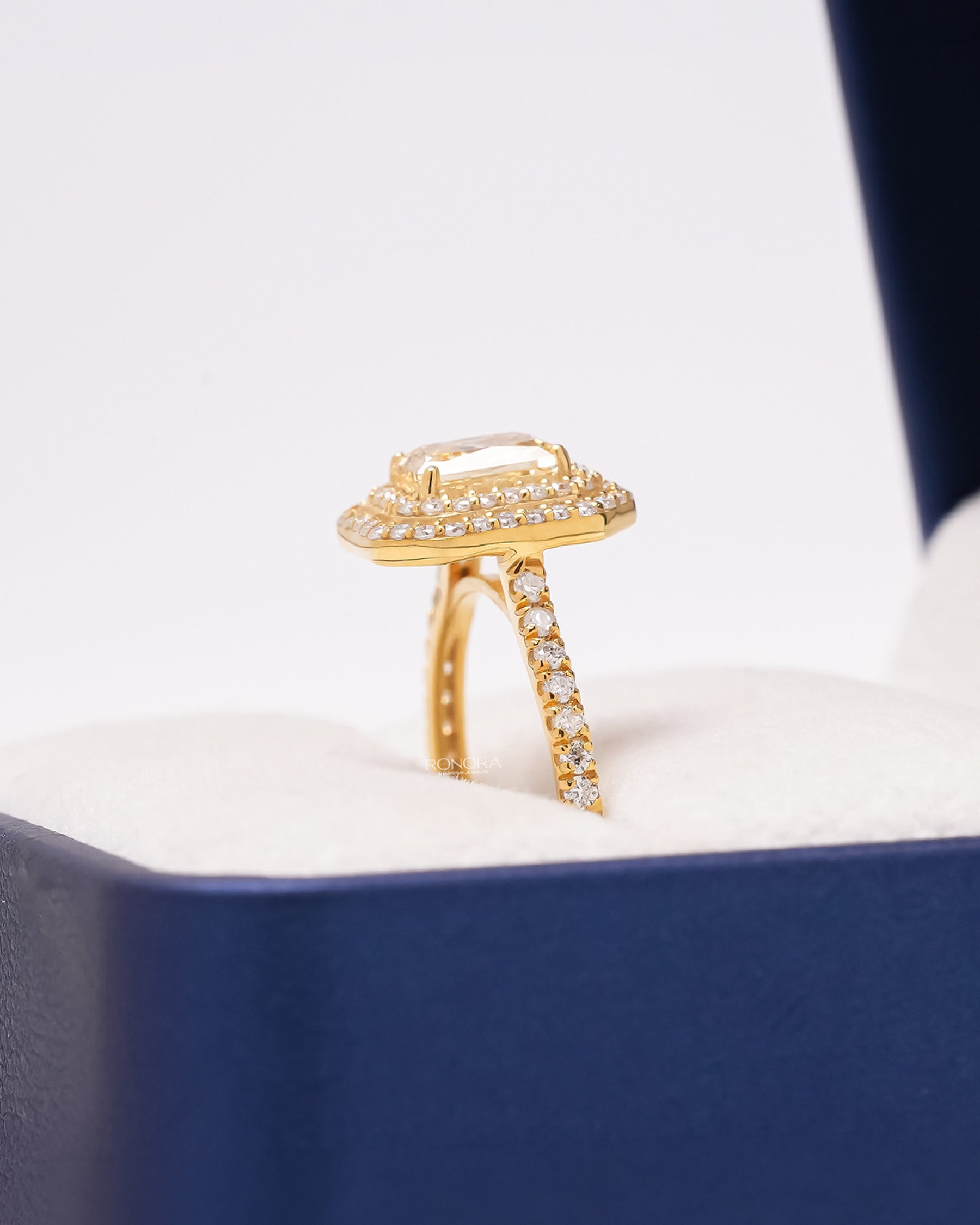 Side profile of yellow radiant lab grown diamond halo ring showing halo pavé setting