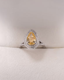 Solara yellow pear lab grown diamond halo ring in white metal inside Ronora box