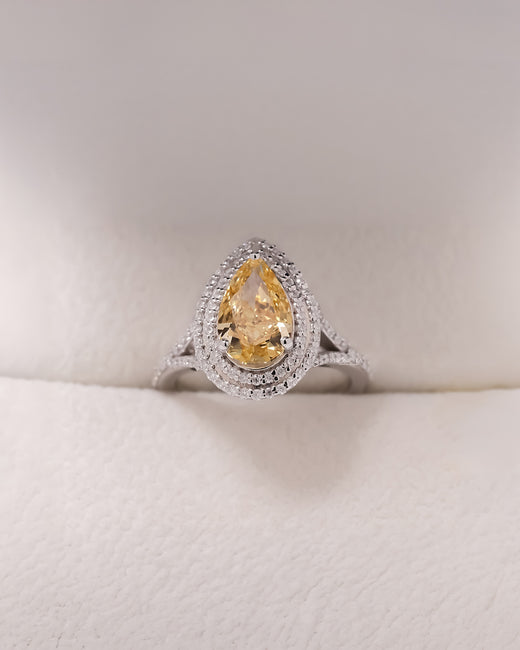 Solara yellow pear lab grown diamond halo ring in white metal inside Ronora box