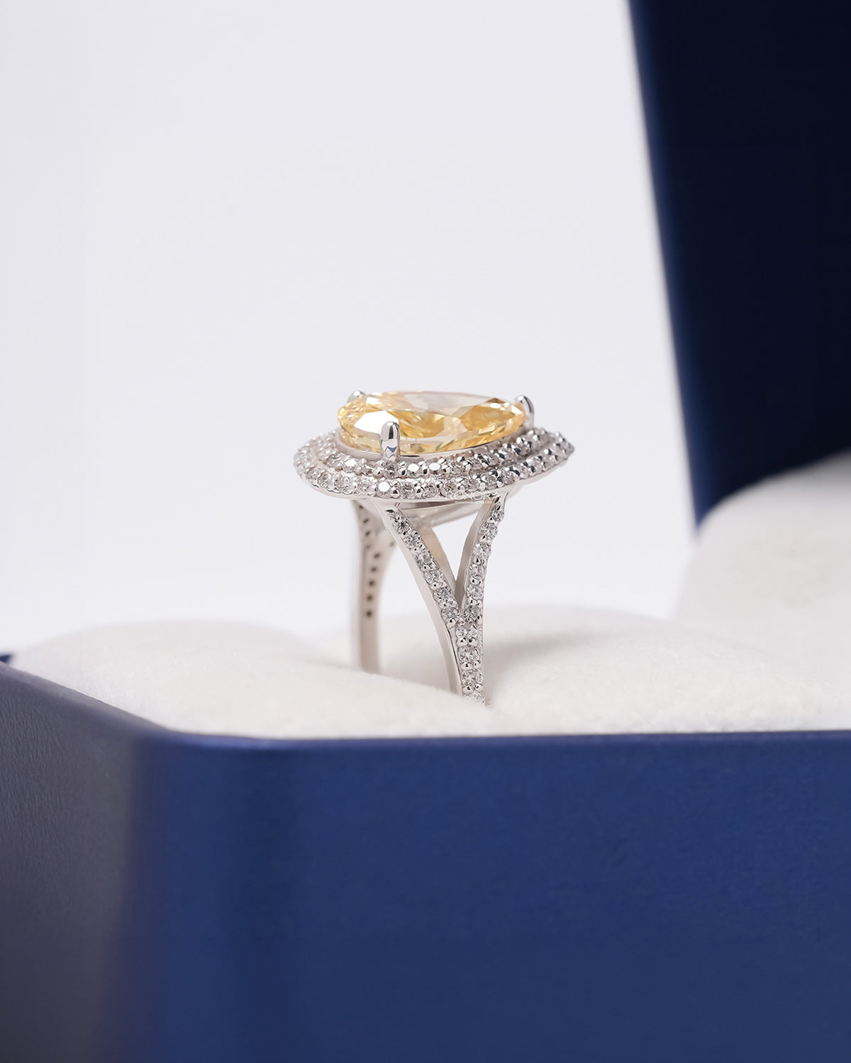Side profile of yellow pear lab grown diamond halo ring showing halo split-shank setting