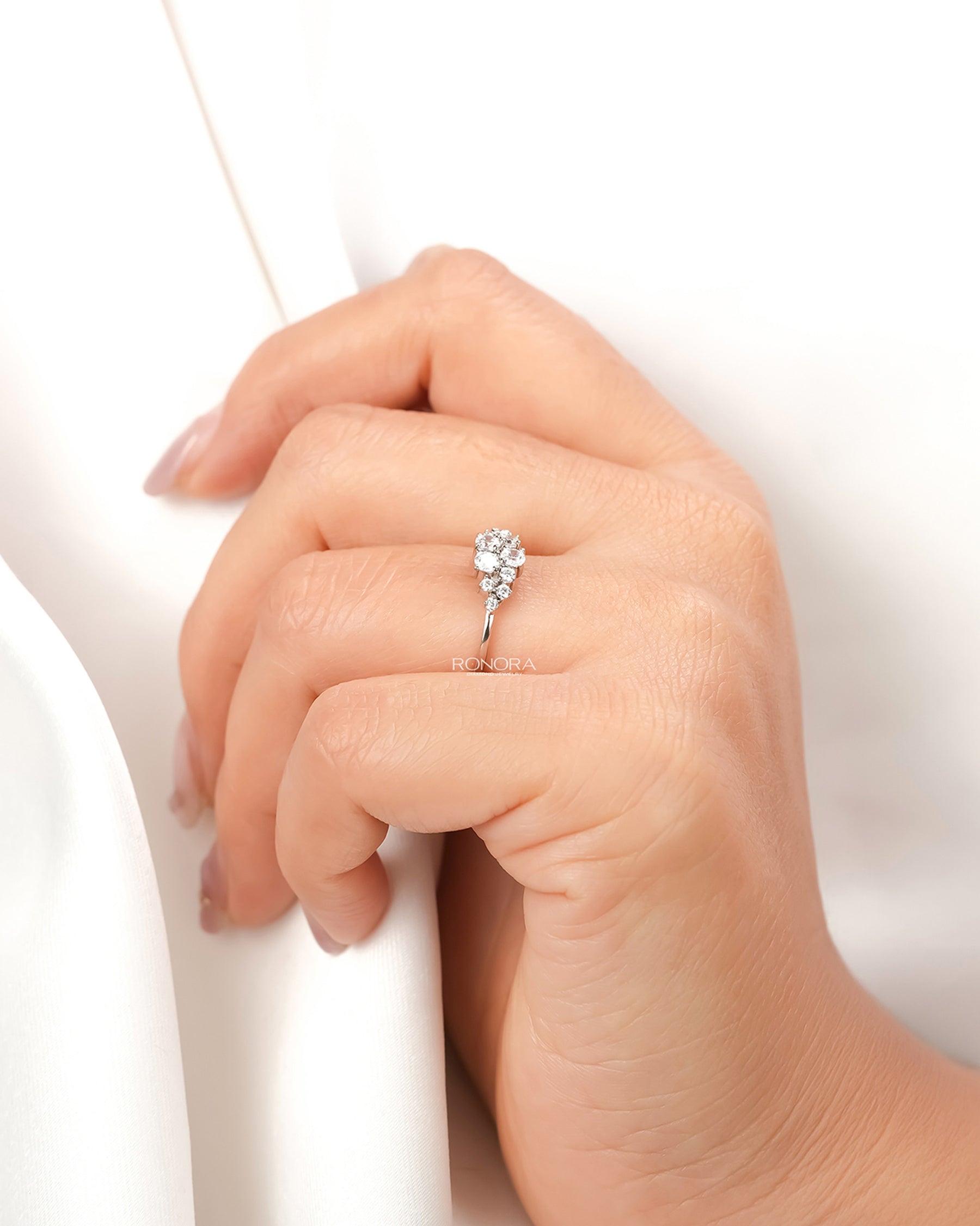 Floral lab grown diamond cluster ring worn with white silk