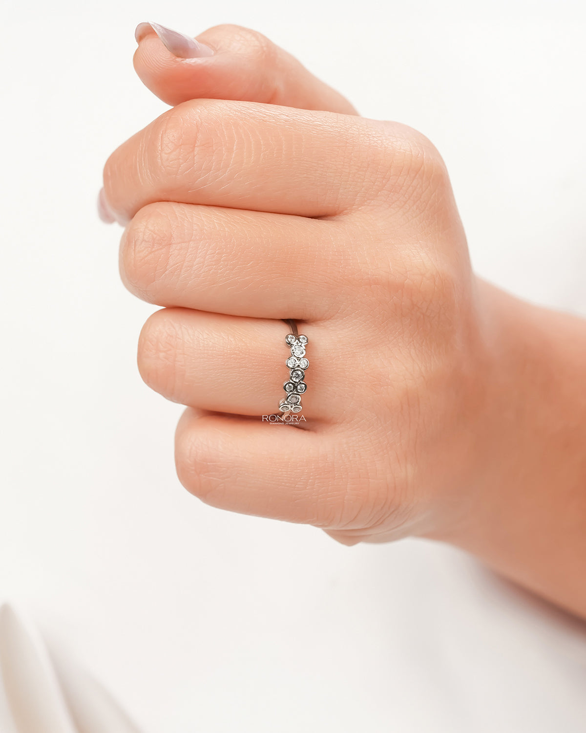Round lab grown diamond five-stone band worn on hand in white metal