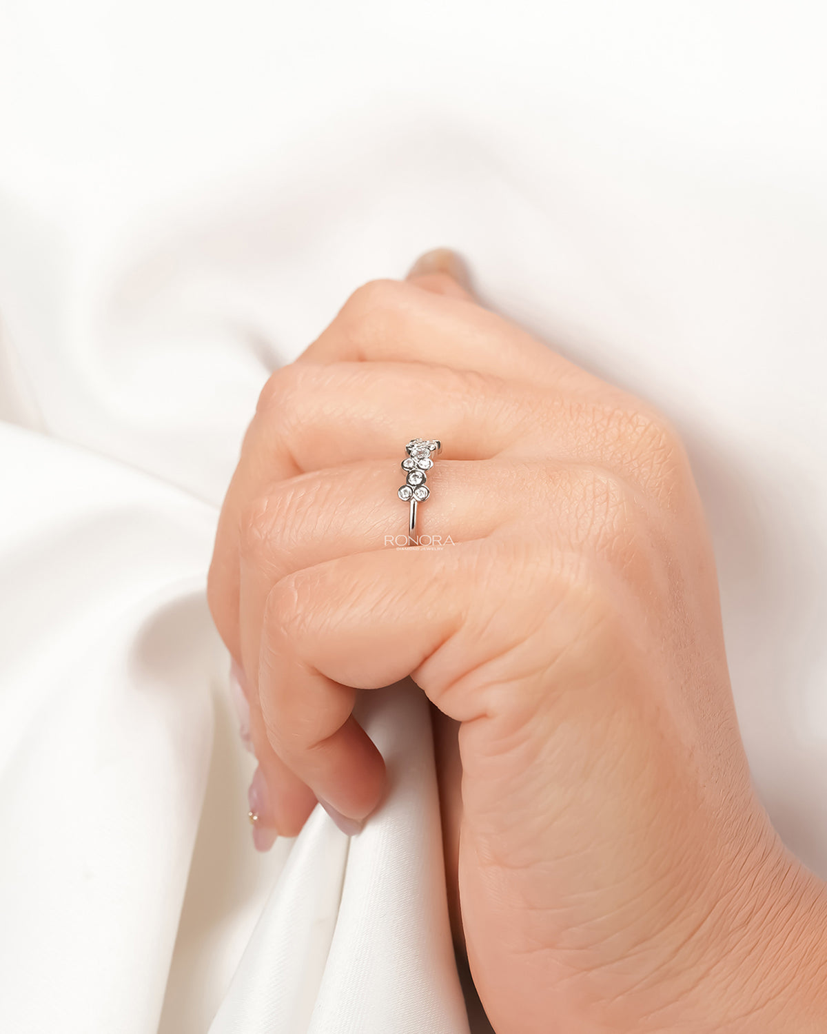 Round lab grown diamond five-stone band worn with white silk