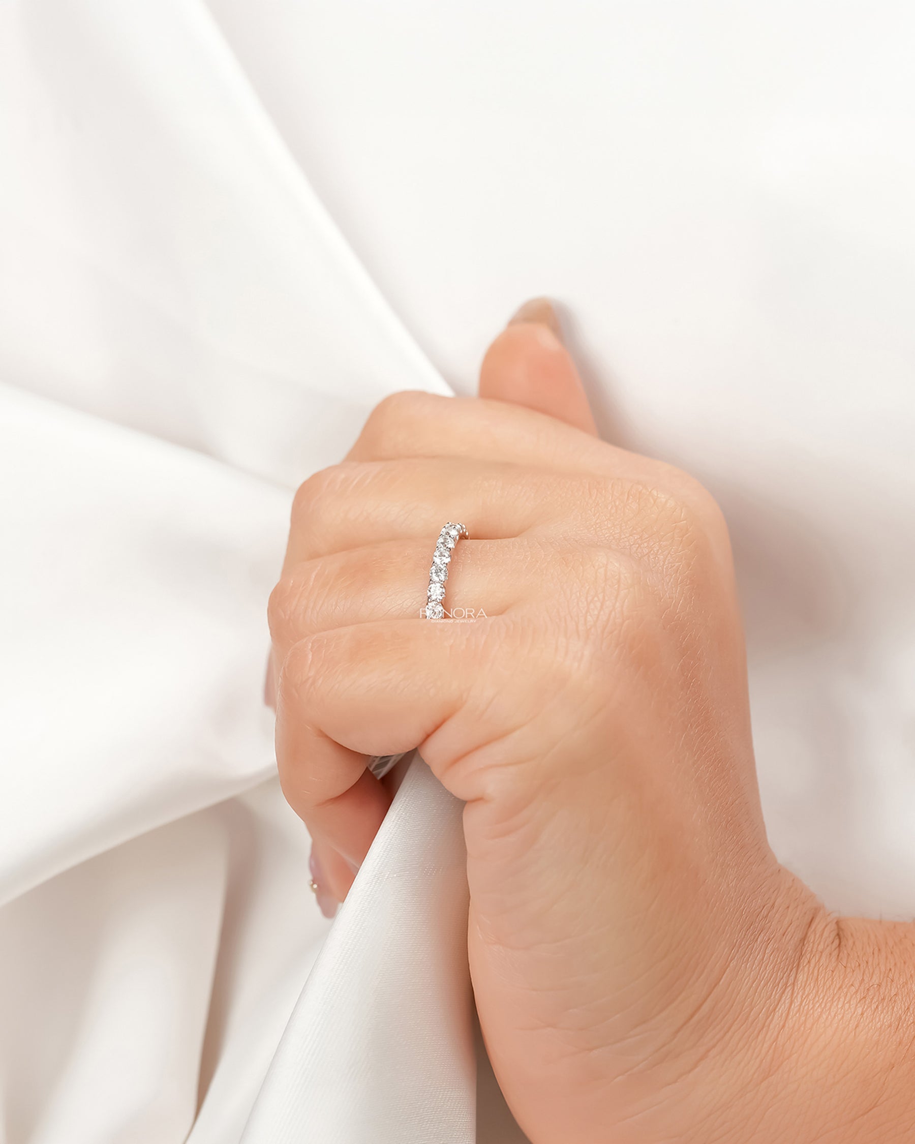 Round lab grown diamond eternity band worn with white silk