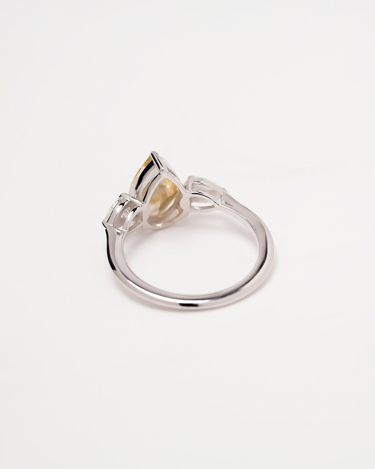 Back view of yellow pear lab grown diamond three-stone ring showing band and gallery detail