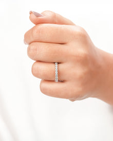 Round lab grown diamond eternity band worn on hand in white metal
