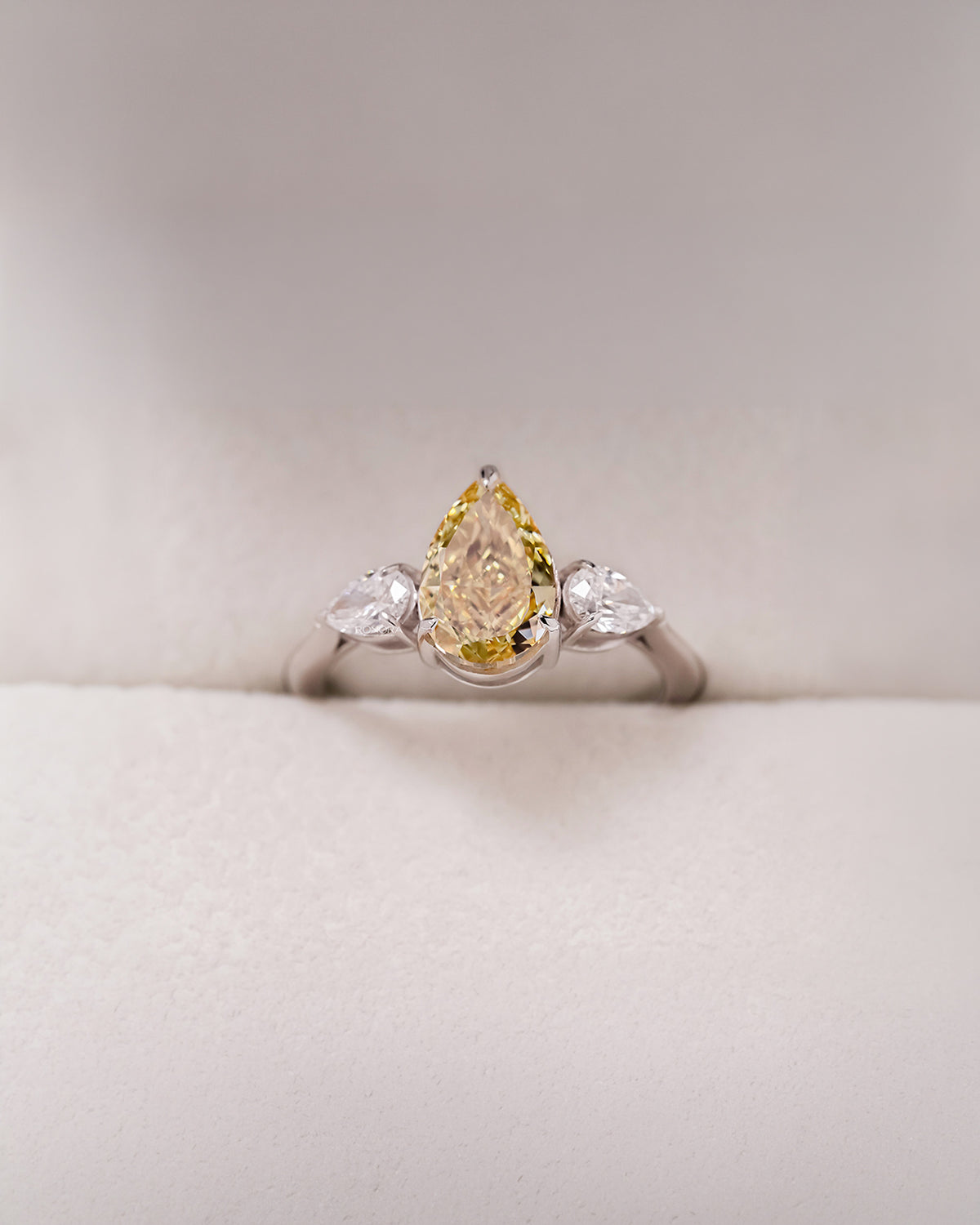 Aureline yellow pear lab grown diamond three-stone ring in white metal inside Ronora box