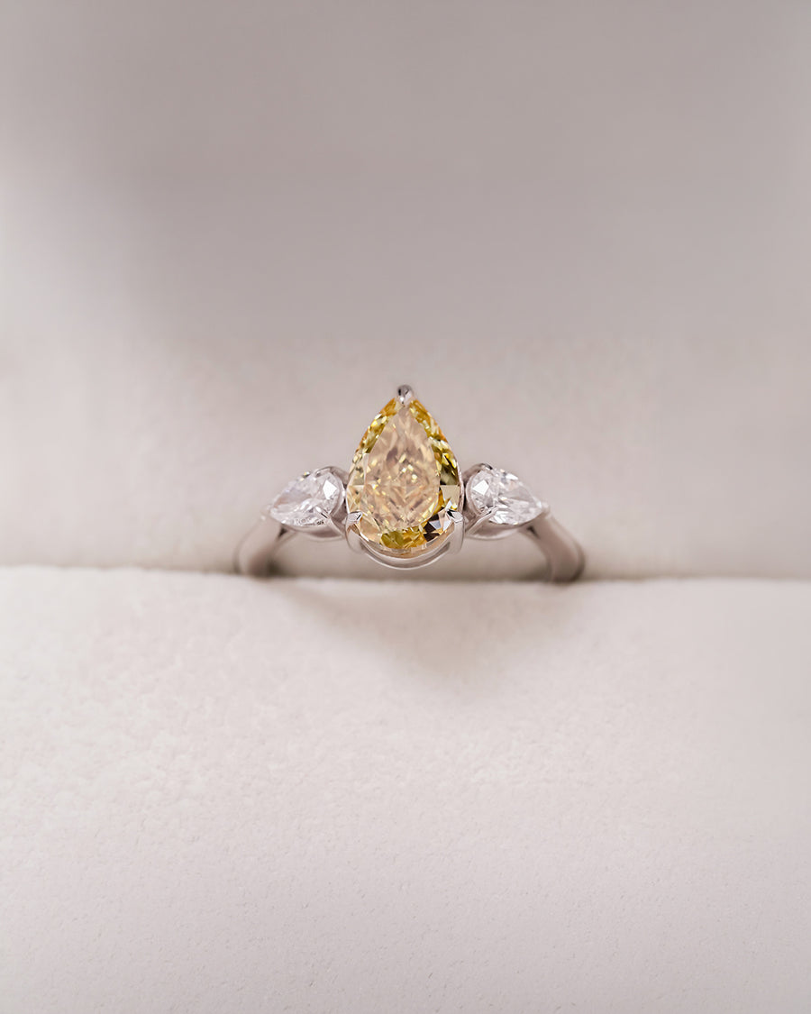 Aureline yellow pear lab grown diamond three-stone ring in white metal inside Ronora box