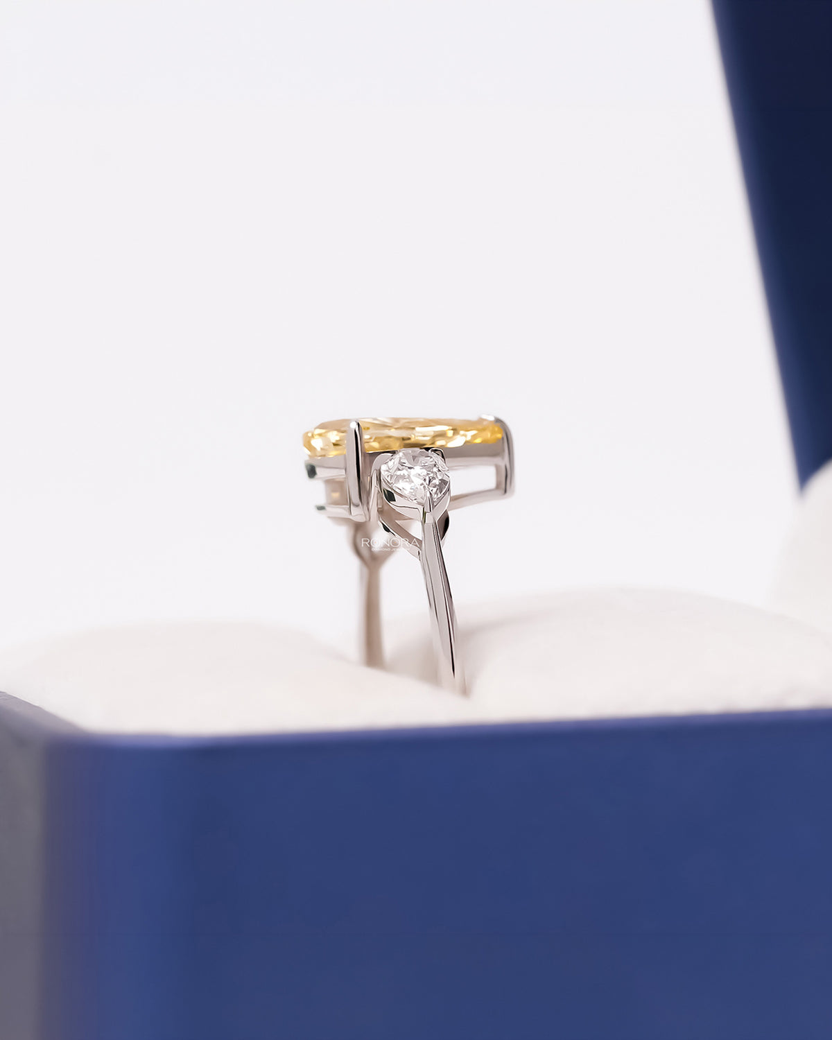 Side profile of yellow pear lab grown diamond three-stone ring showing three-stone setting