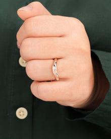 Blue accent lab grown diamond curved ring worn on hand in rose gold