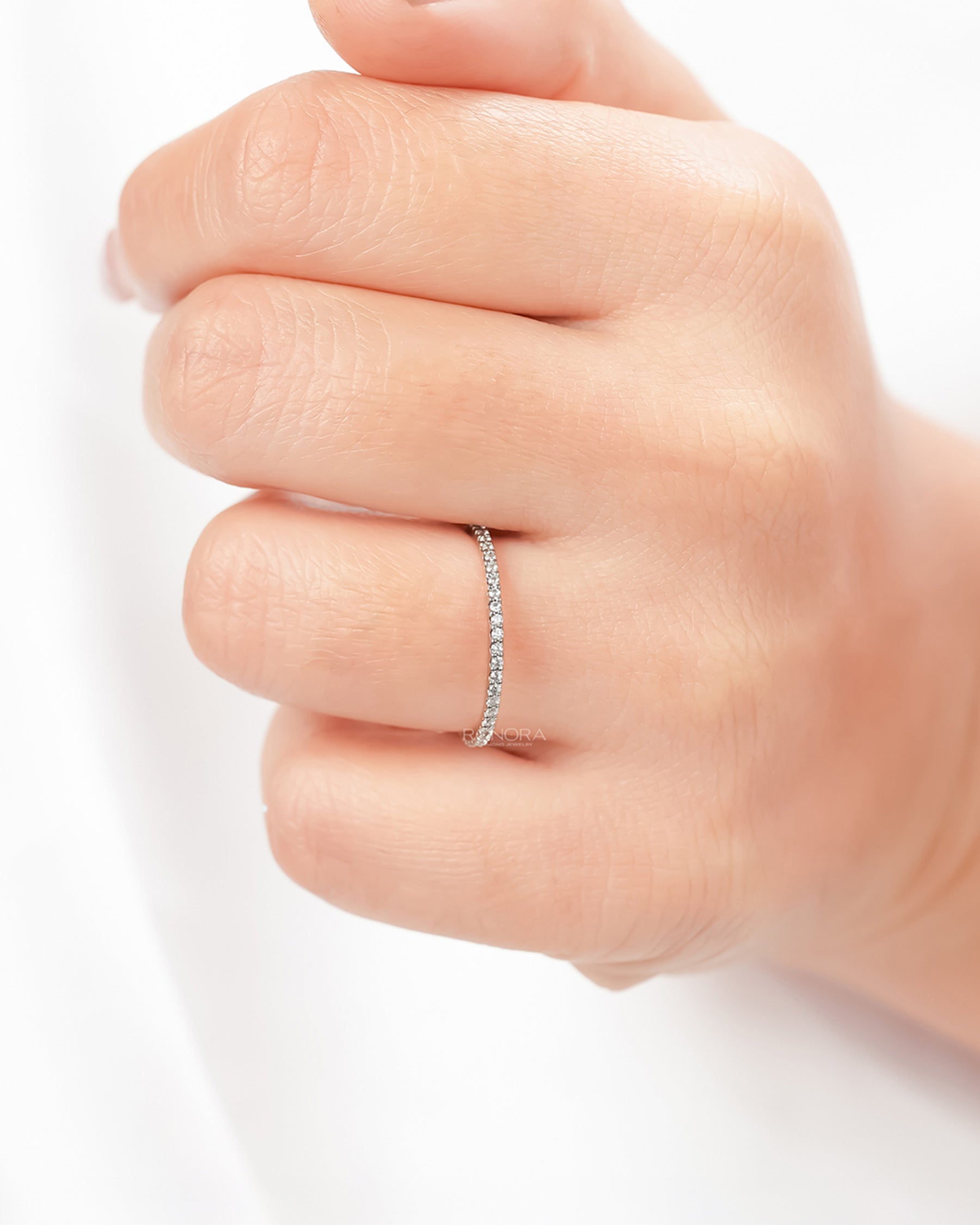 Slim lab grown diamond pavé eternity band worn on hand in rose gold