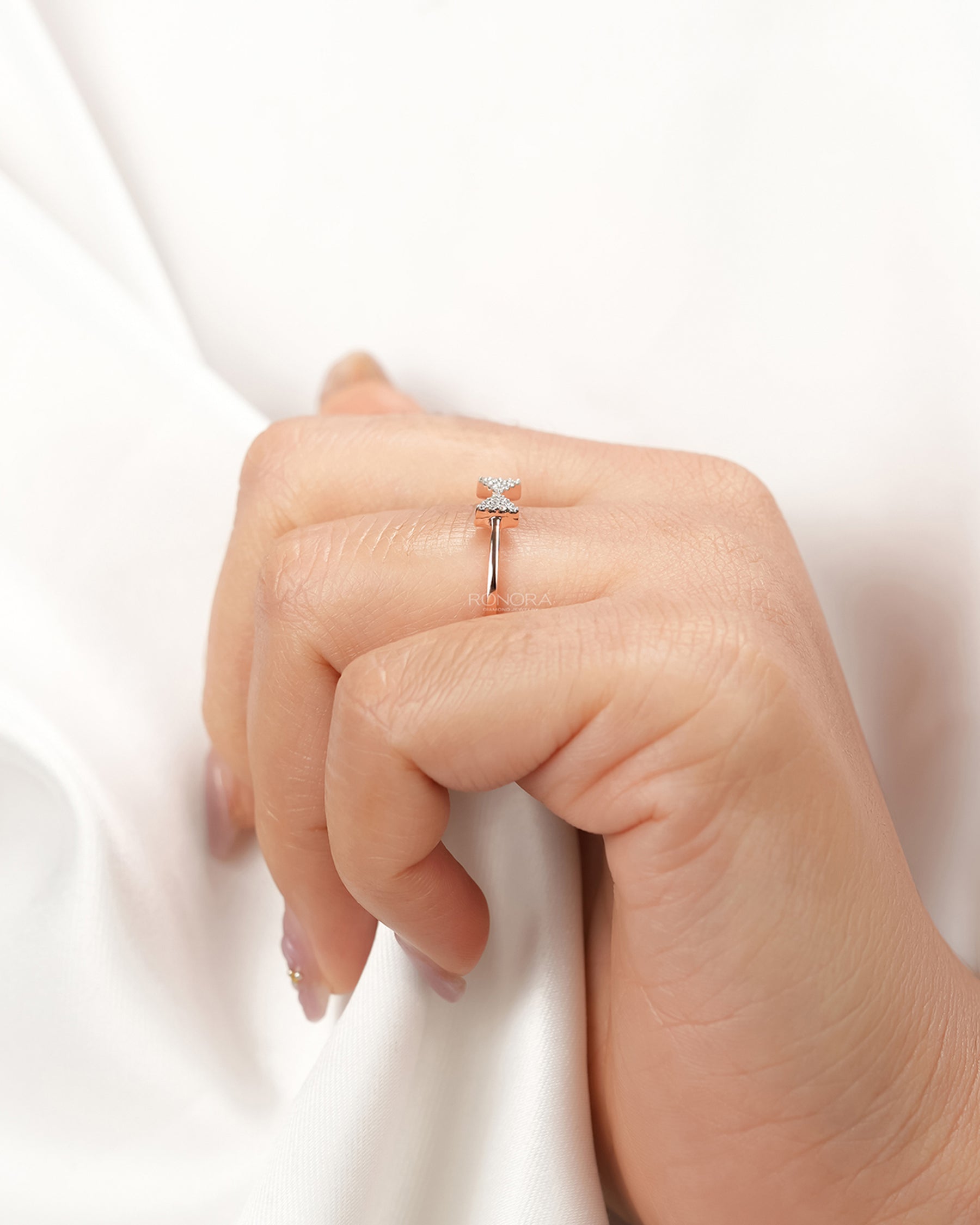 Delicate pavé bow lab grown diamond ring worn with white silk