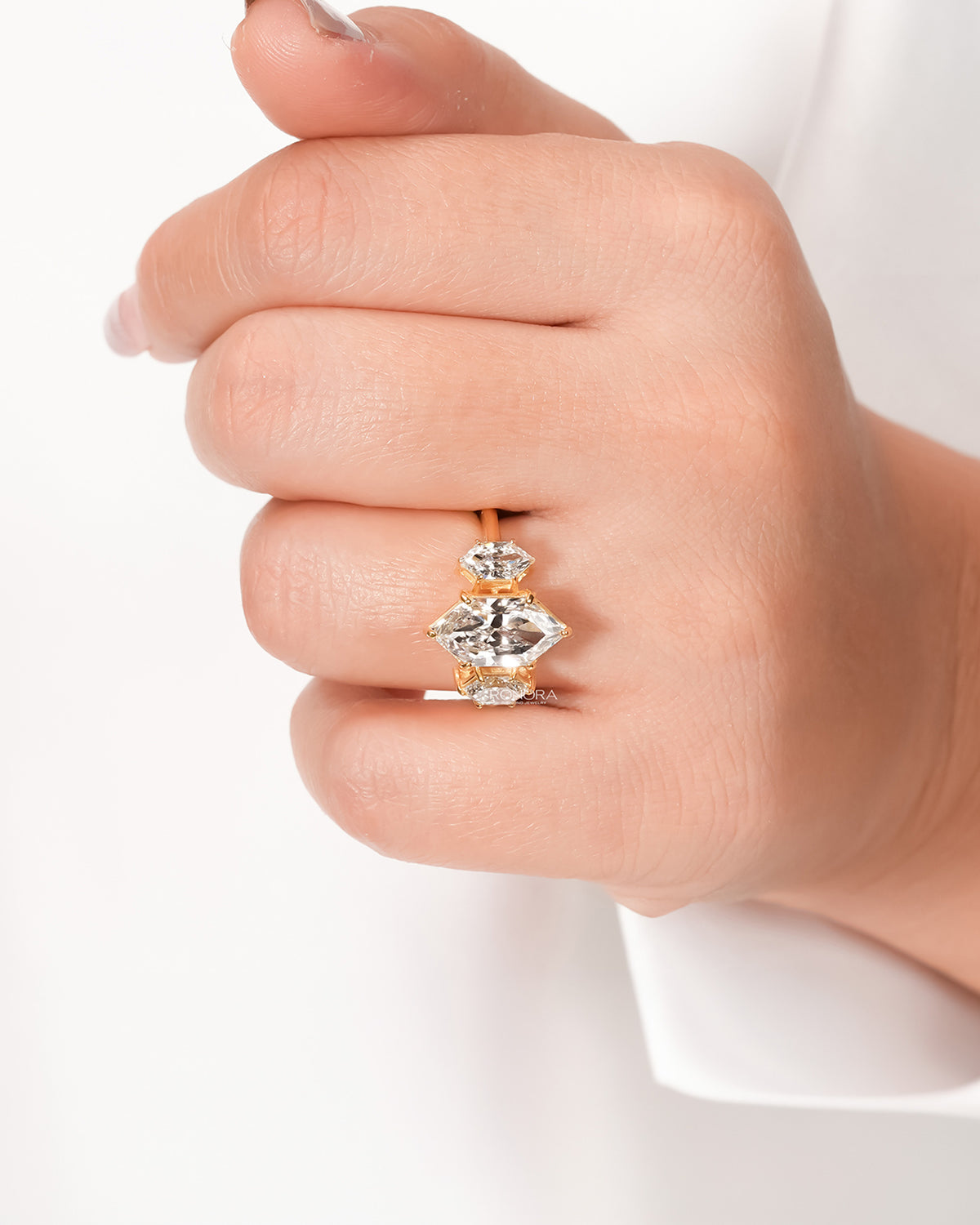 Marquise lab grown diamond three-stone ring worn on hand in yellow gold