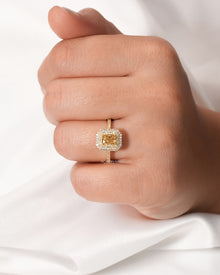Yellow radiant lab grown diamond halo ring worn on hand in yellow gold