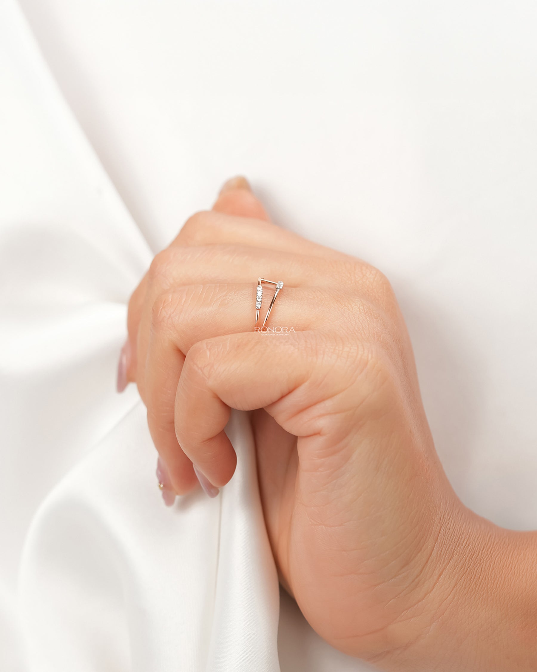 Open rose gold lab grown diamond bypass ring worn with white silk