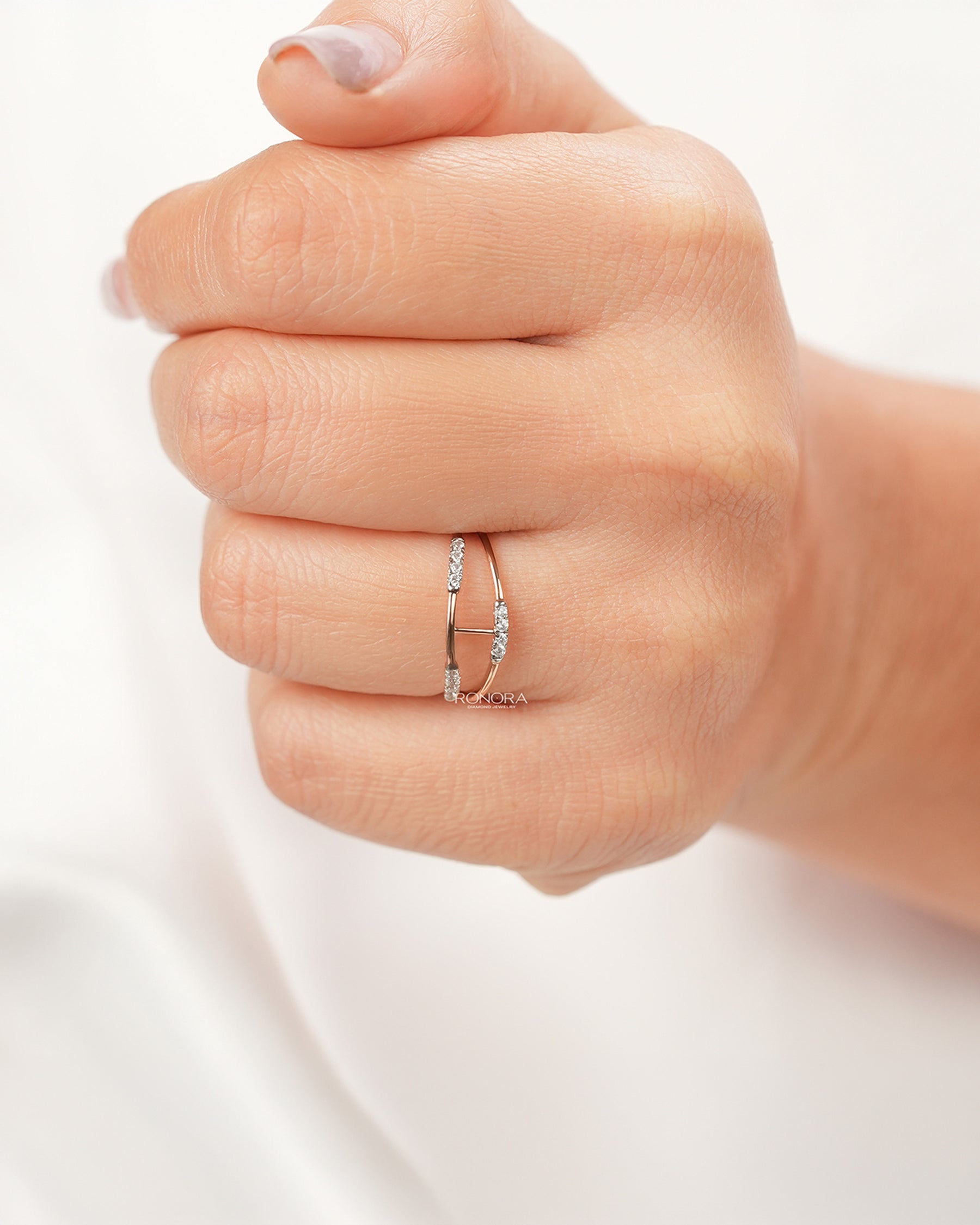 Open lab grown diamond bypass ring worn on hand in rose gold