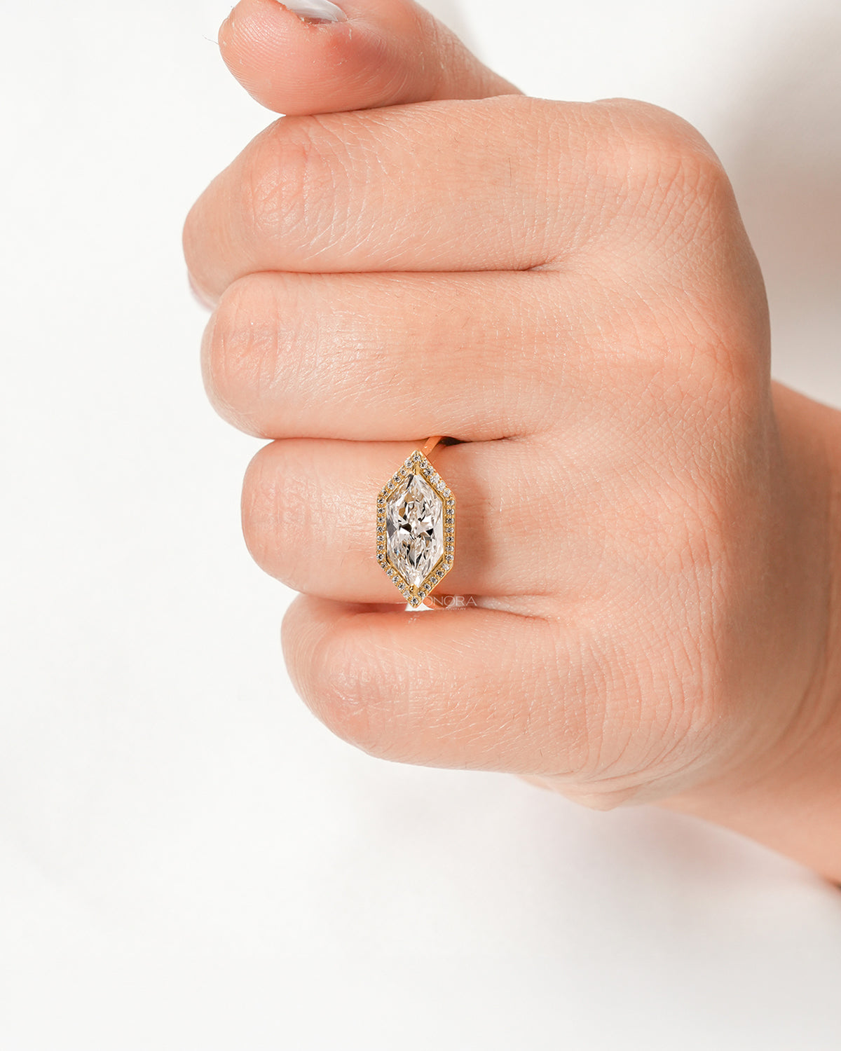 Marquise lab grown diamond halo ring worn on hand in yellow gold