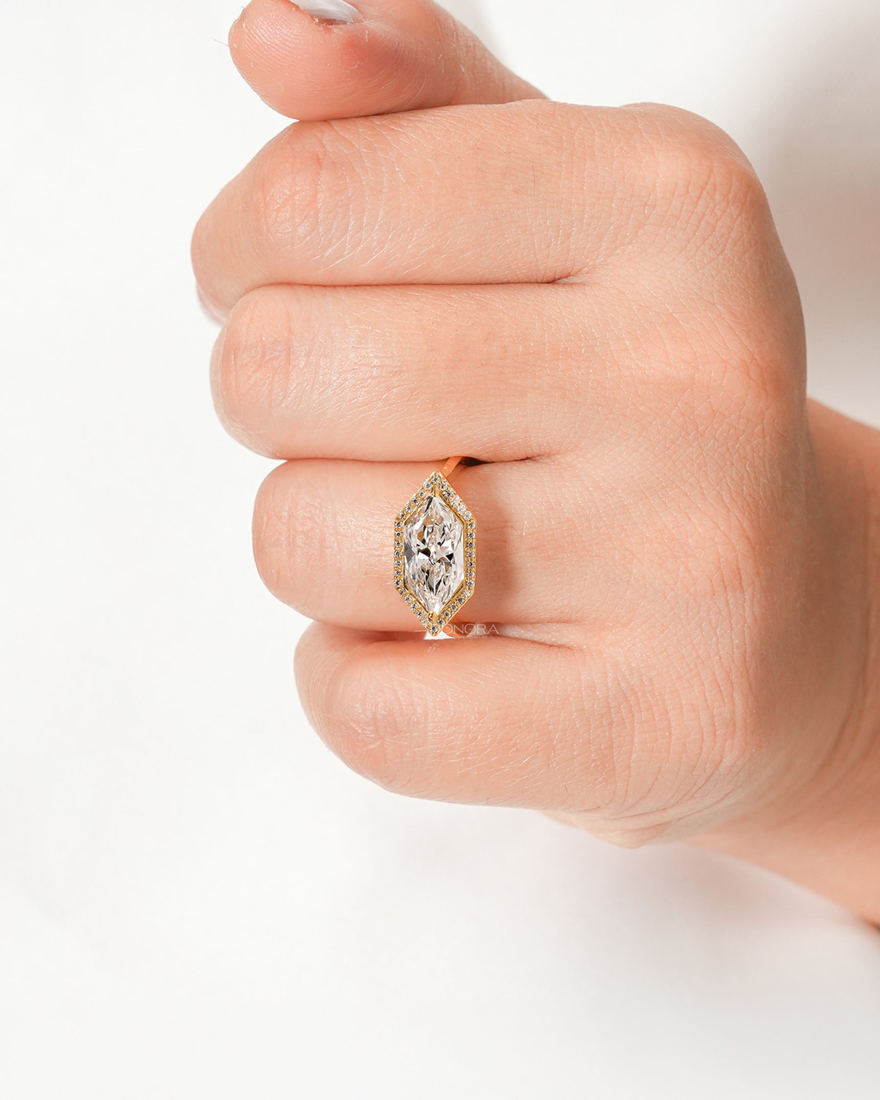 Marquise lab grown diamond halo ring worn on hand in yellow gold