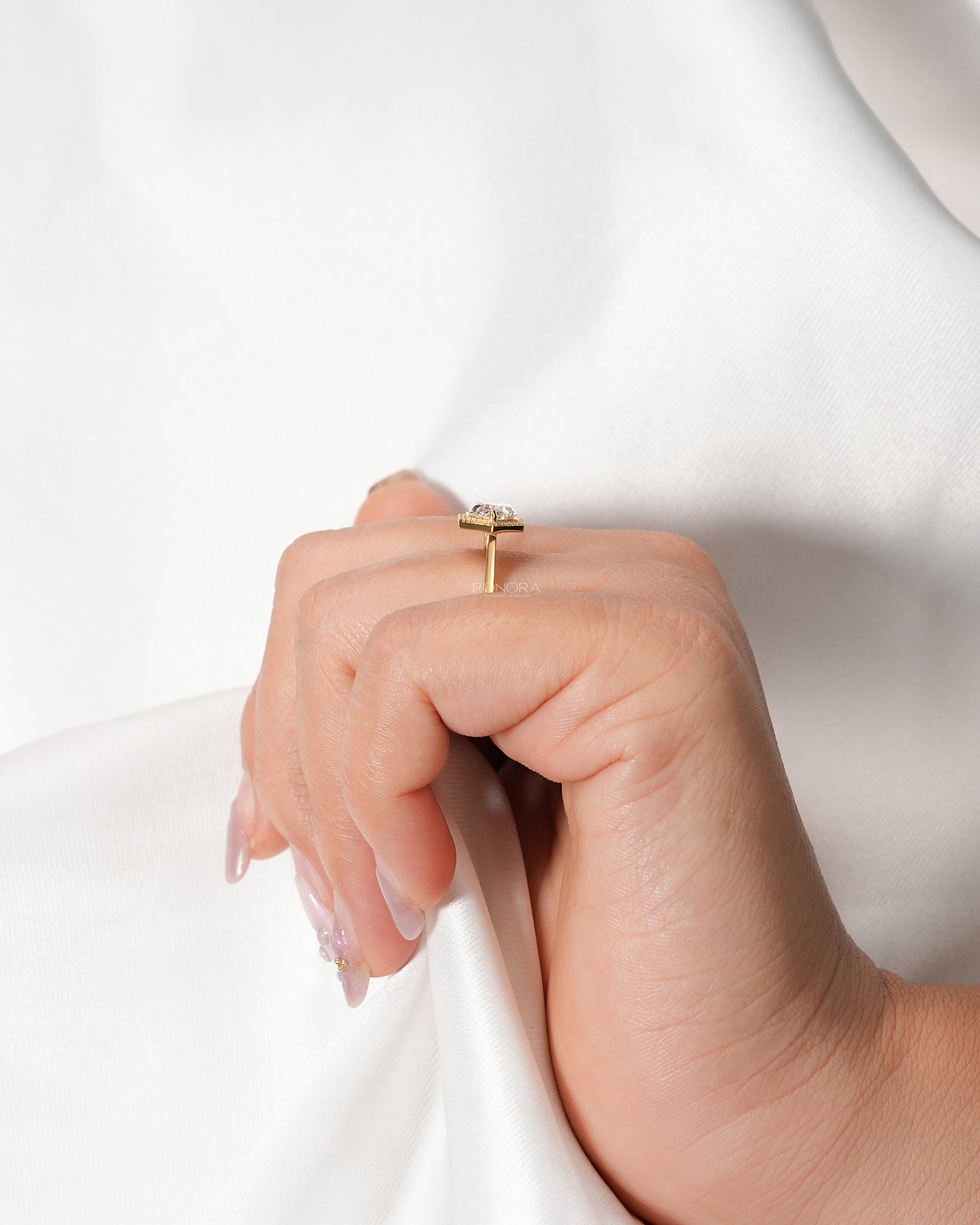 Marquise halo lab grown diamond ring worn with white silk