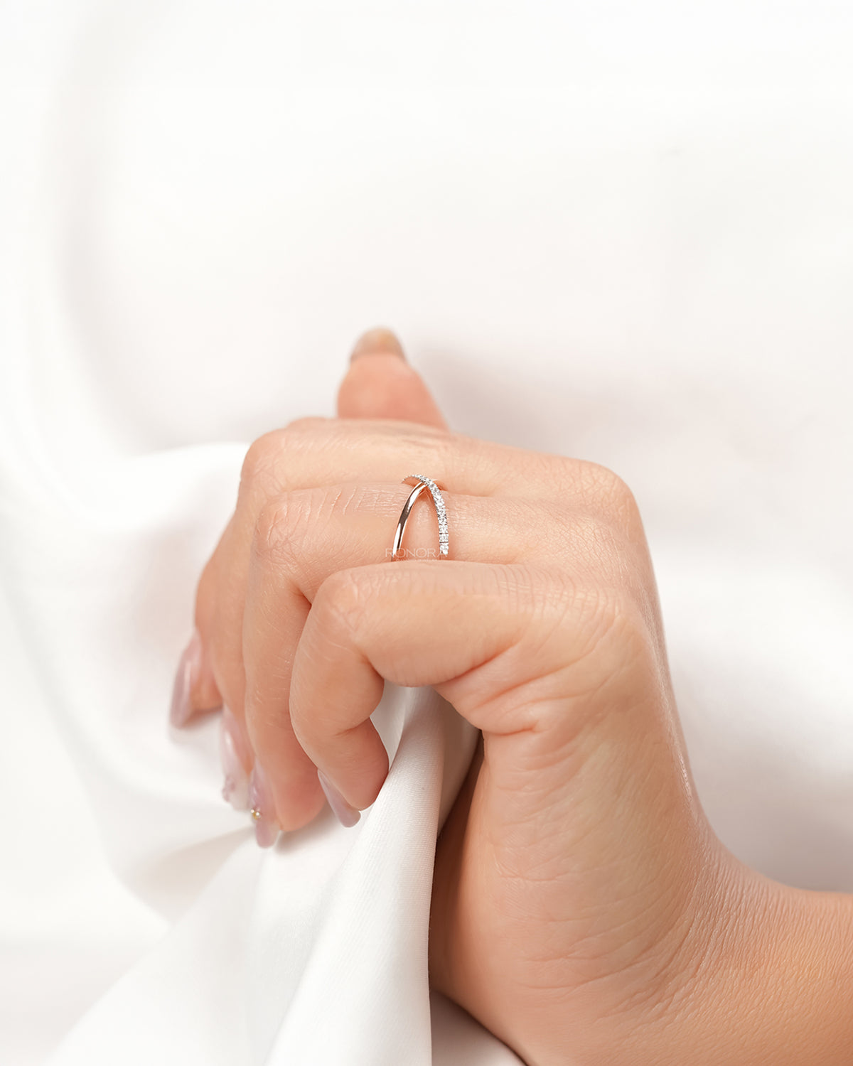 Twisted rose gold lab grown diamond pavé ring worn with white silk