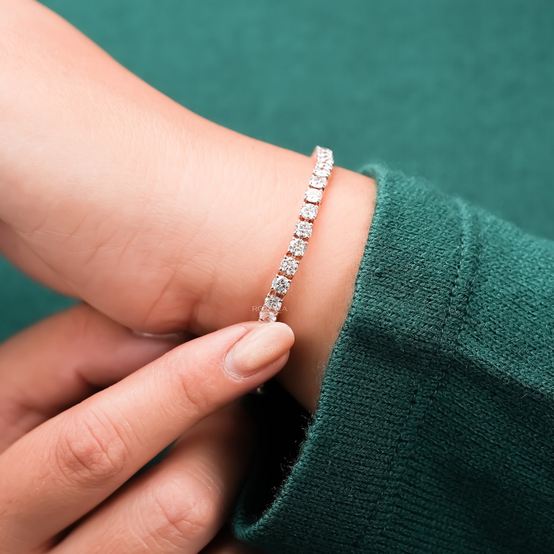 Round lab grown diamond tennis bracelet being adjusted on wrist