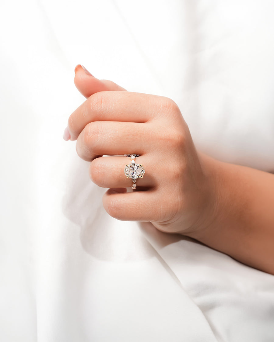 Oval marquise lab grown diamond three-stone ring worn on hand in yellow gold
